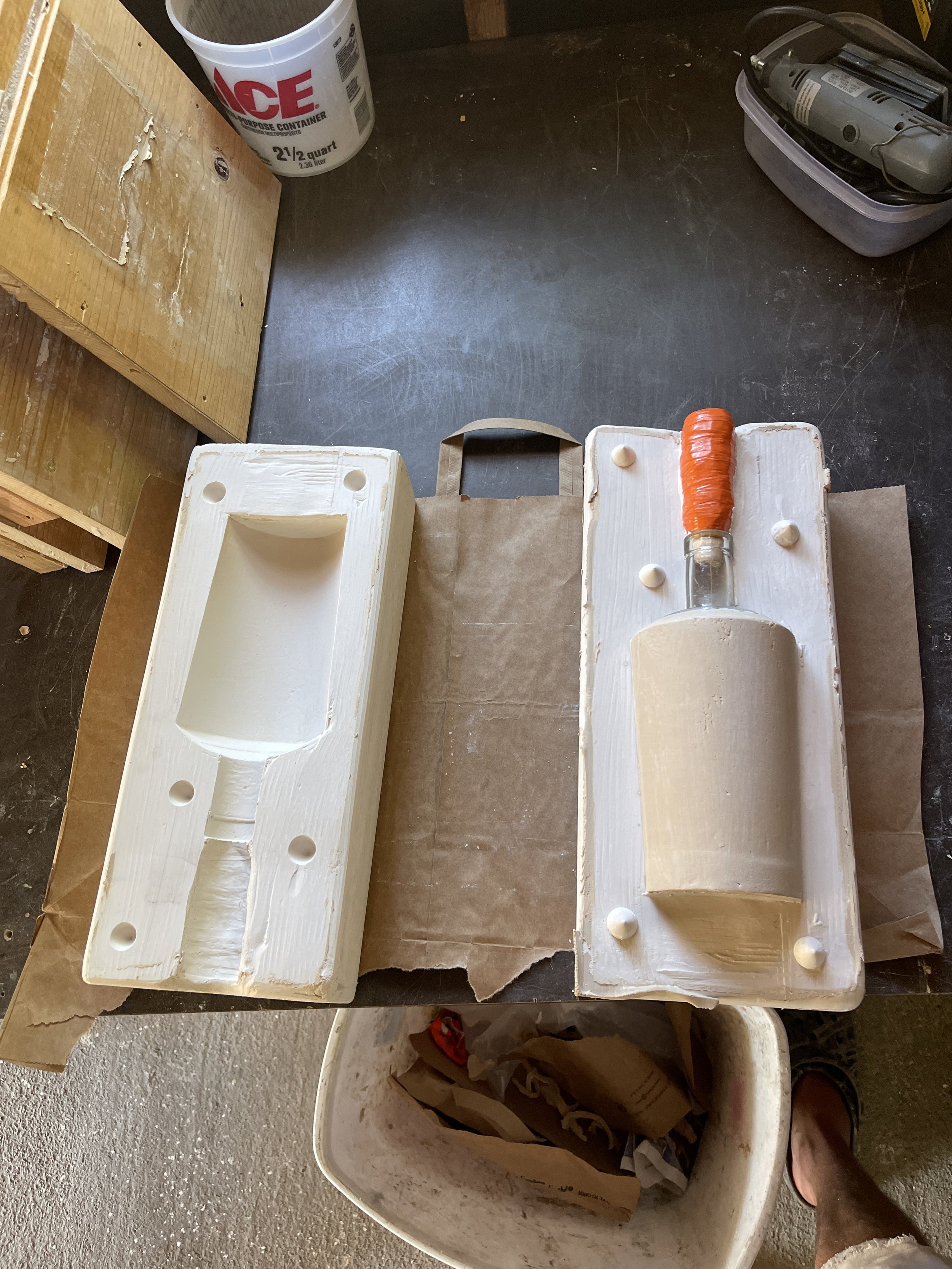 Two-part mold with clay object and handle on a workbench