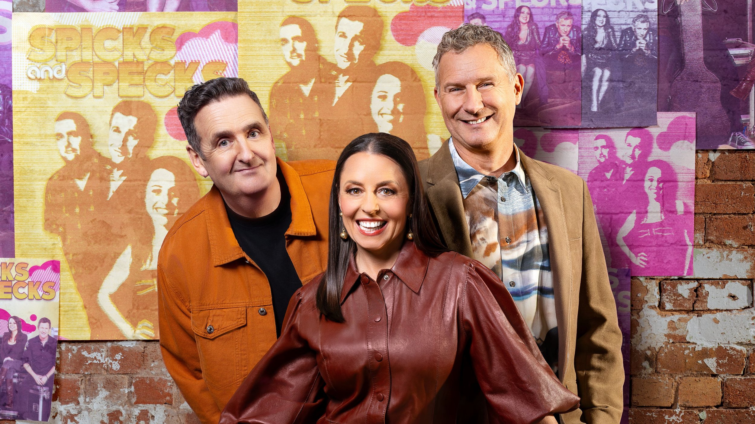 three presenters stand in front of a brcik wall that's plastered with band posters