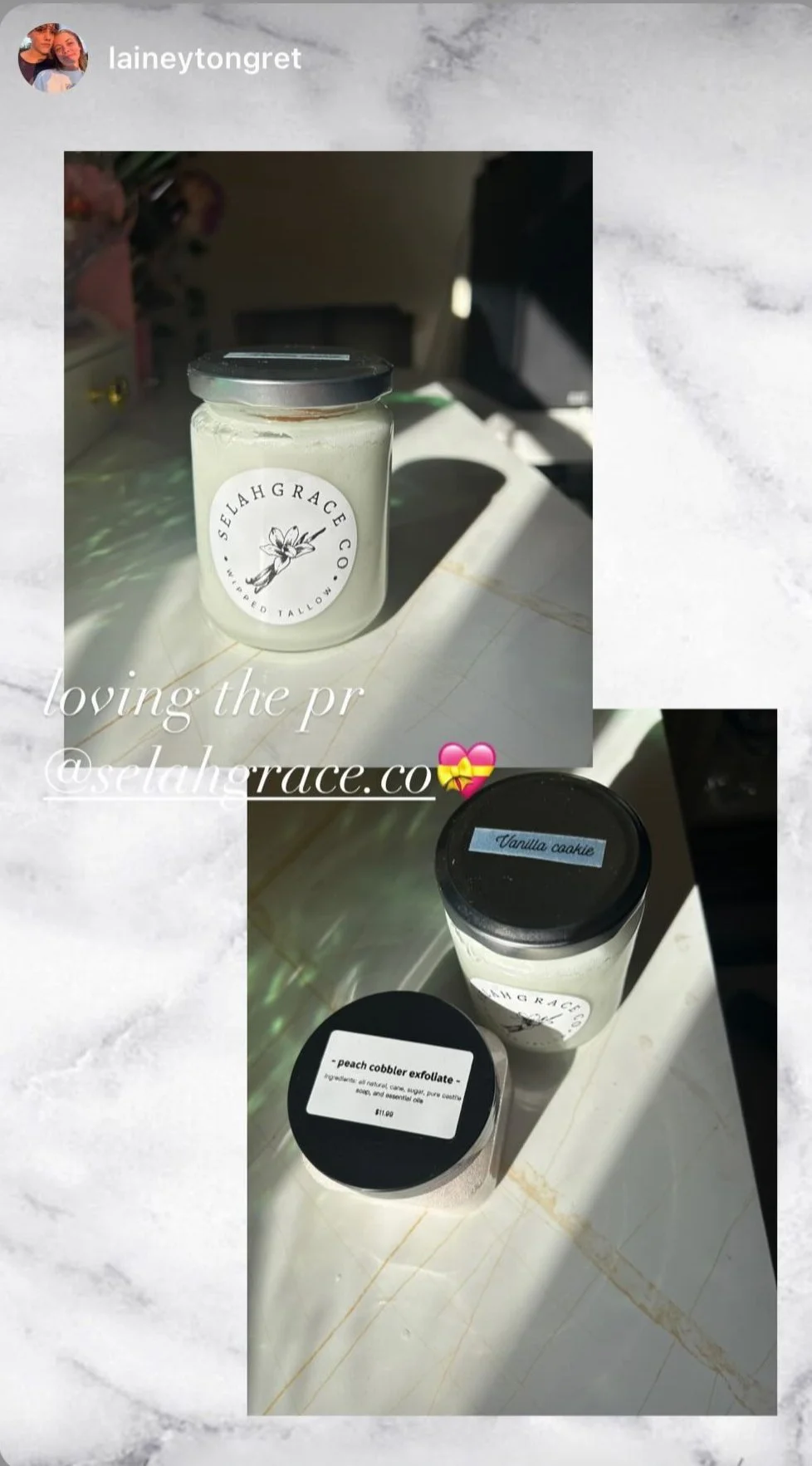 A candle labeled 'Sehlah Grace Co with a vanilla cookie scent, a jar of 'peach cobbler exfoliate,' and a vanilla cookie candle on a marble countertop with sunlight casting shadows.