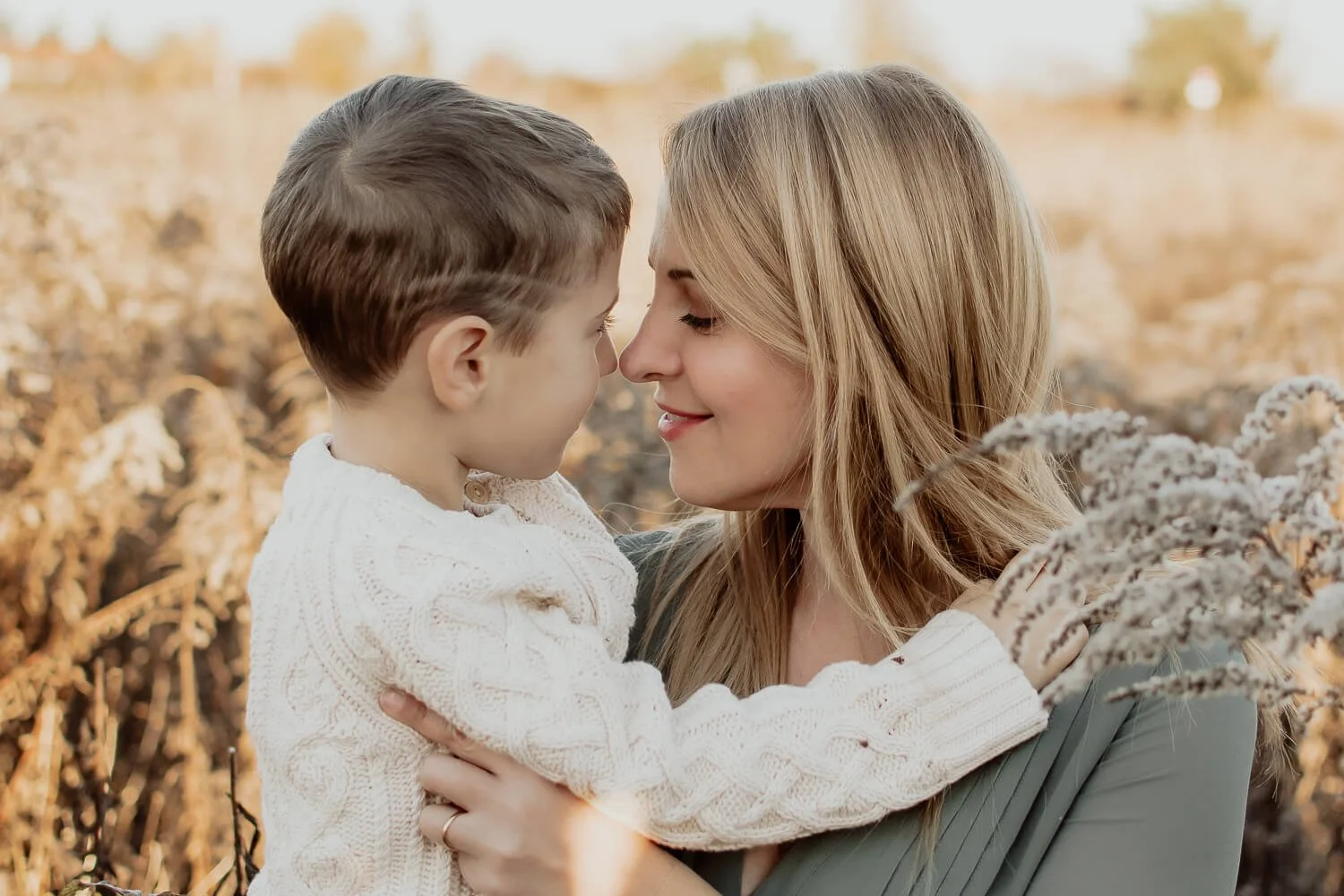Mutter kuschelt mit Sohn in Natur beim Outdoorfotoshooting. Mama LIeb