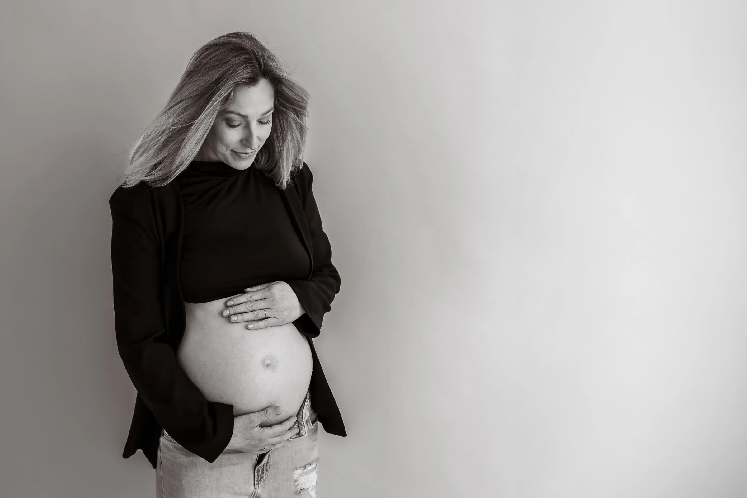 Schwangerschaftsfotoshooting am Riemer See in München: Schwangere Frau im Boho-Stil in winterlicher Naturkulisse.