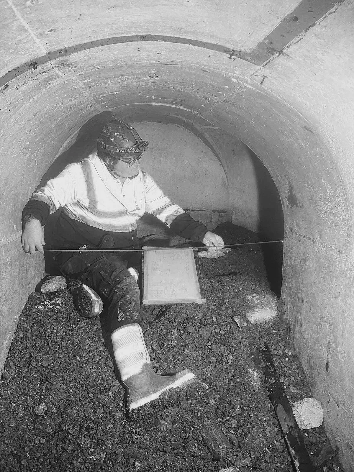 Silhouette of a person with short hair in front of a gray background.