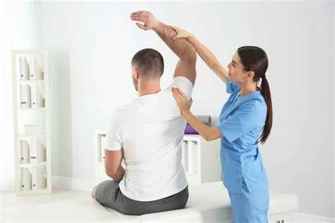 Physical therapist aiding a man with shoulder stretching exercises