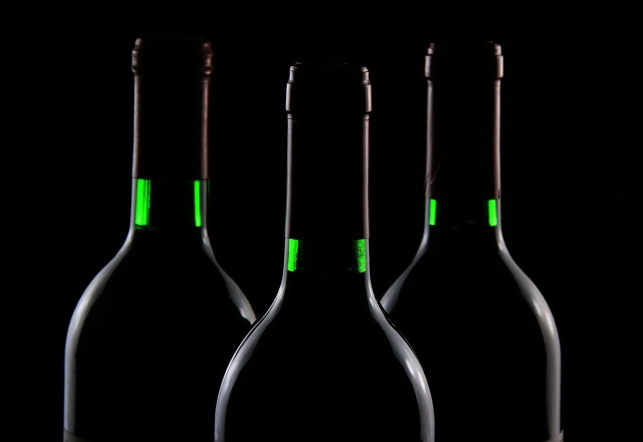 Trois bouteilles de vin sur fond noir.