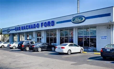 Gus Machado Ford car dealership building with parked cars in front.