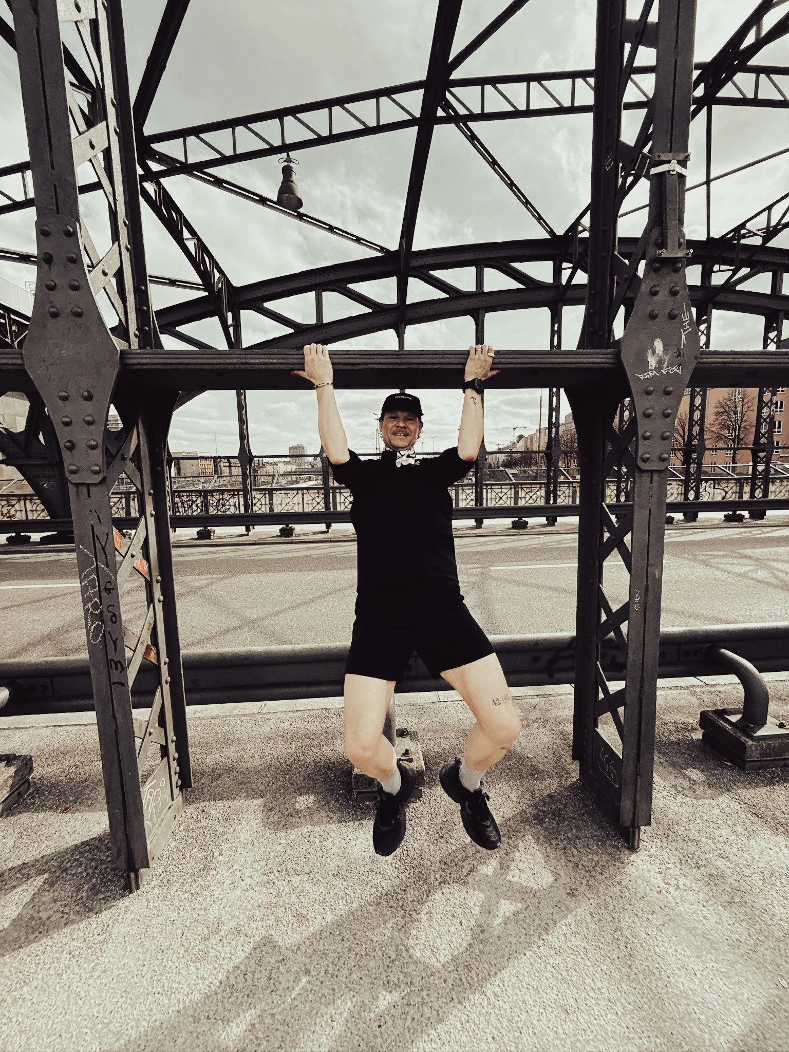 Krafttraining für Läufer: Klimmzug an einer Eisenbahnbrücke im Freien