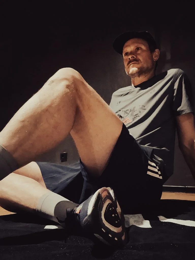 Läufer sitzt auf Yoga-Matte – Dehnung und Flexibilität