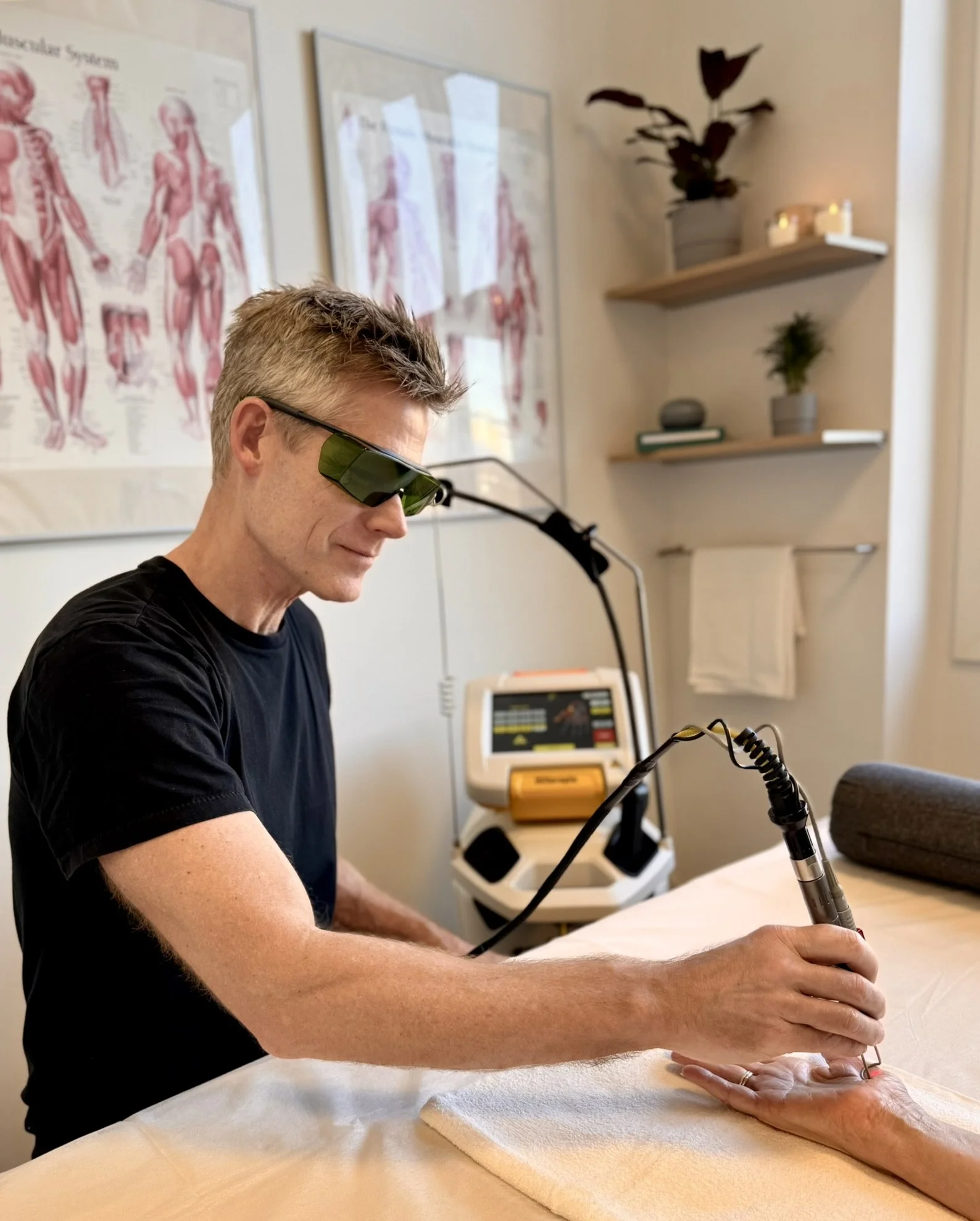 Behandler bruger ASAlaser sikkerhedsbriller ved håndholdt laserbehandling. Laserbriller til præcis og sikker medicinsk laserterapi.