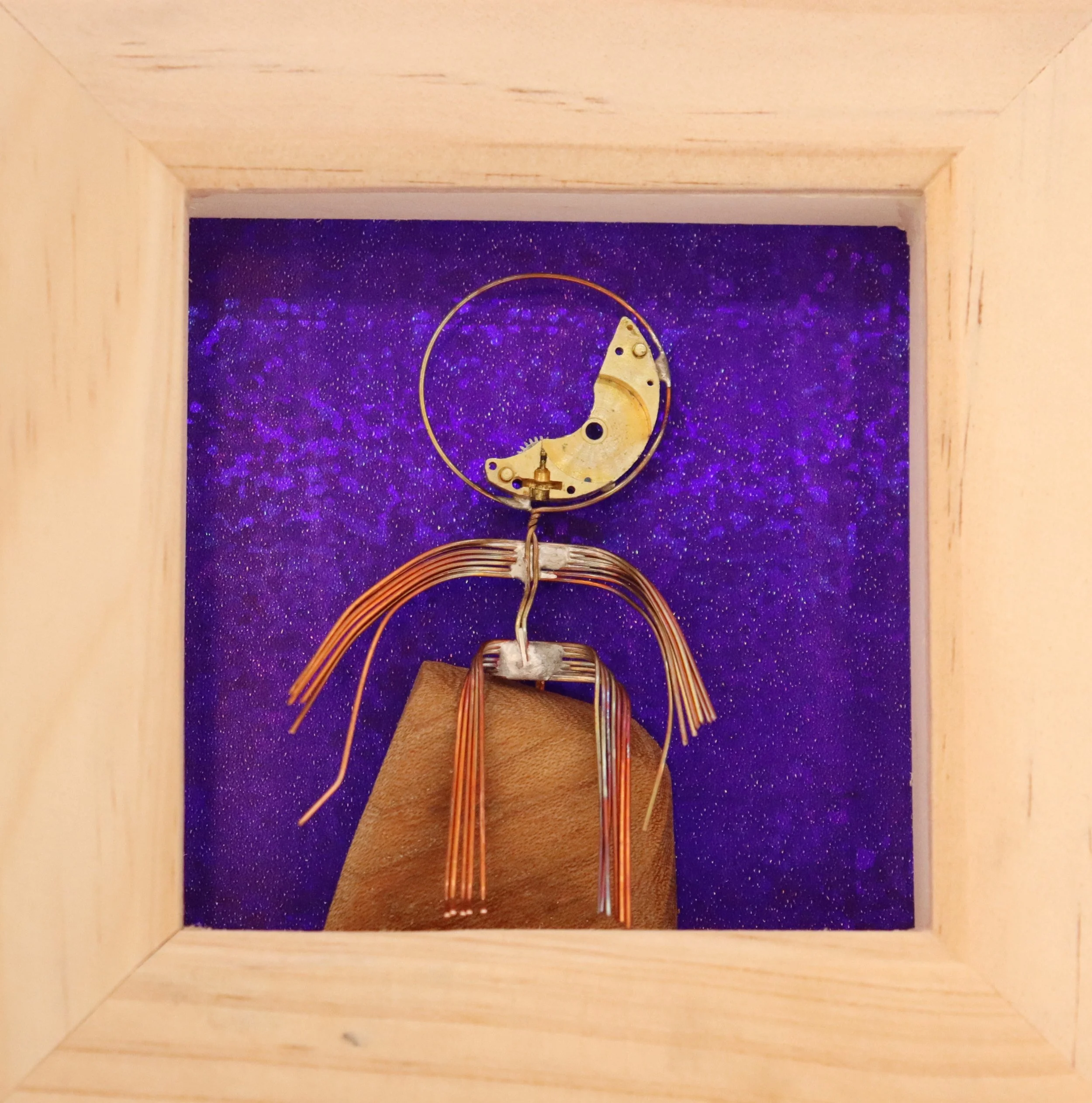 An abstract sculpture resembling a human figure with a circular head and thin body made of metal and wires, set against a purple starry background.