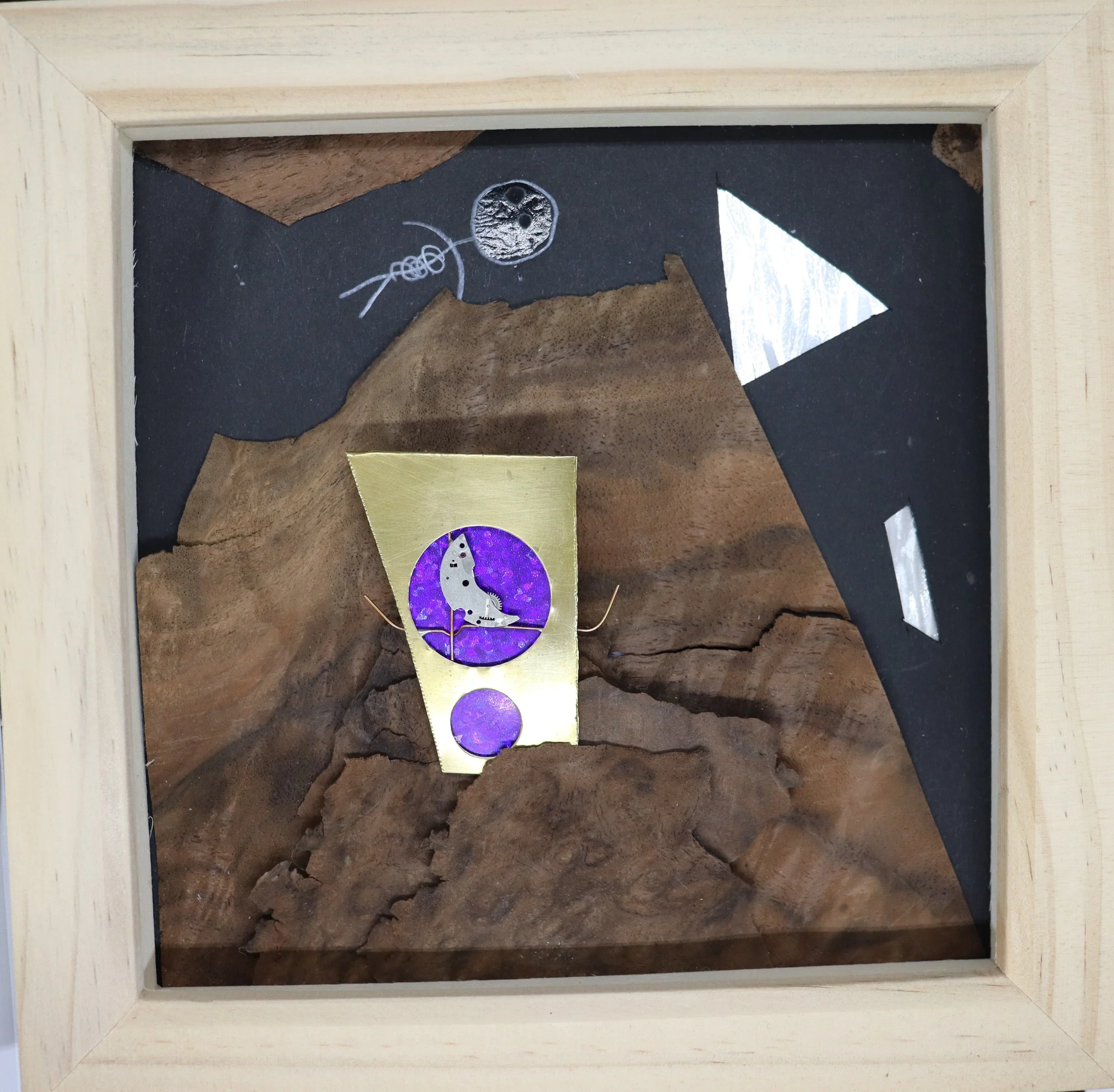Mixed media artwork featuring a wooden background with geometric shapes, metallic accents, and an illustration of a dinosaur within a purple circle.