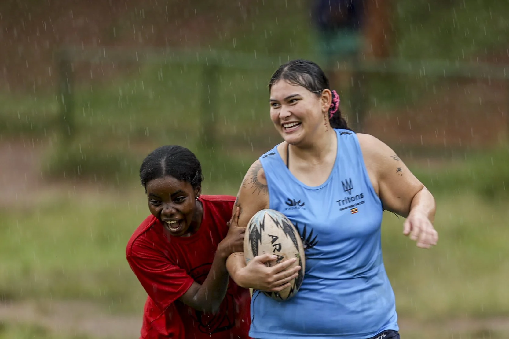 Women playing rugby during Tritons tour in Uganda showing match action and energy.