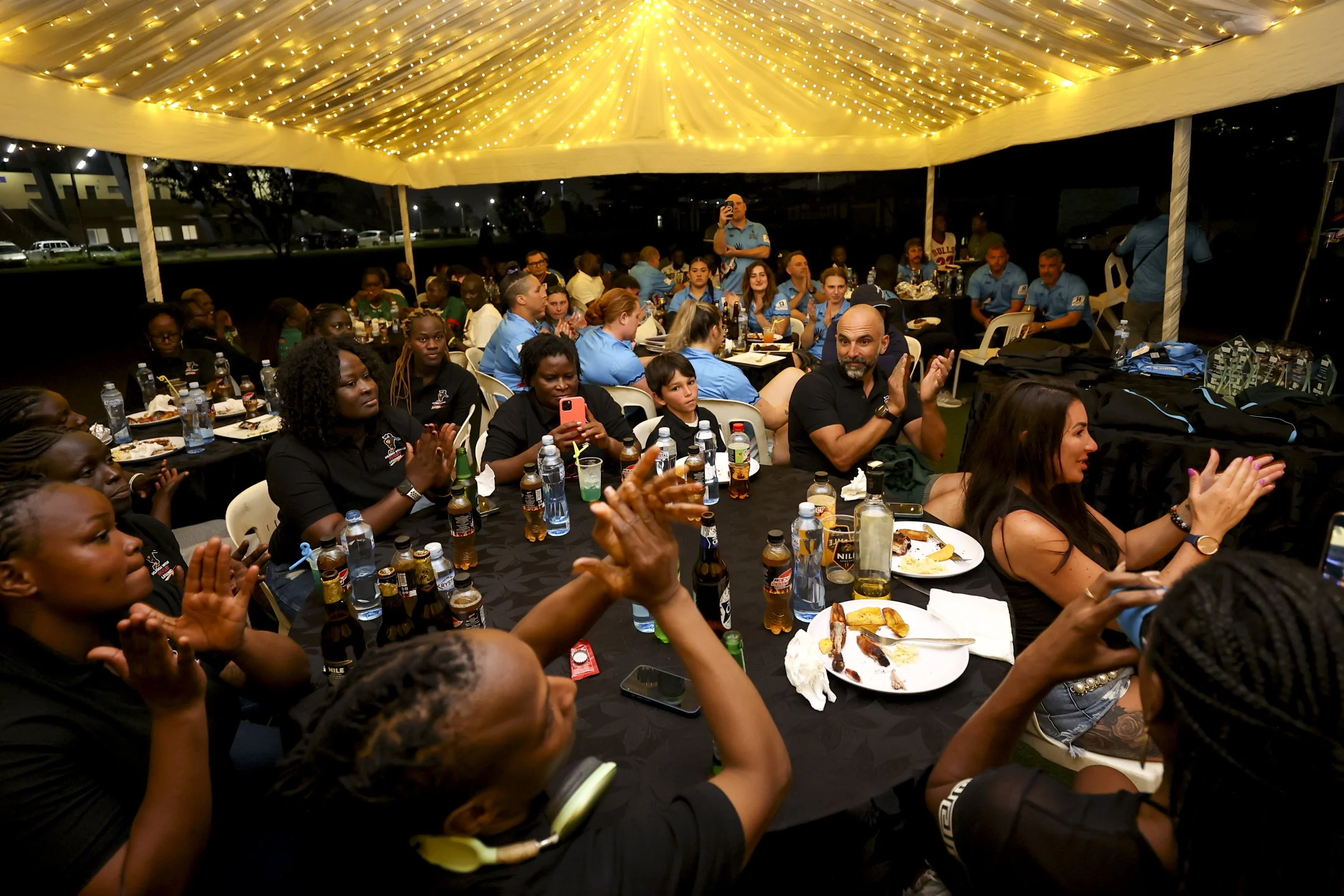 Tritons rugby tour group enjoying evening social event during Uganda tour experience