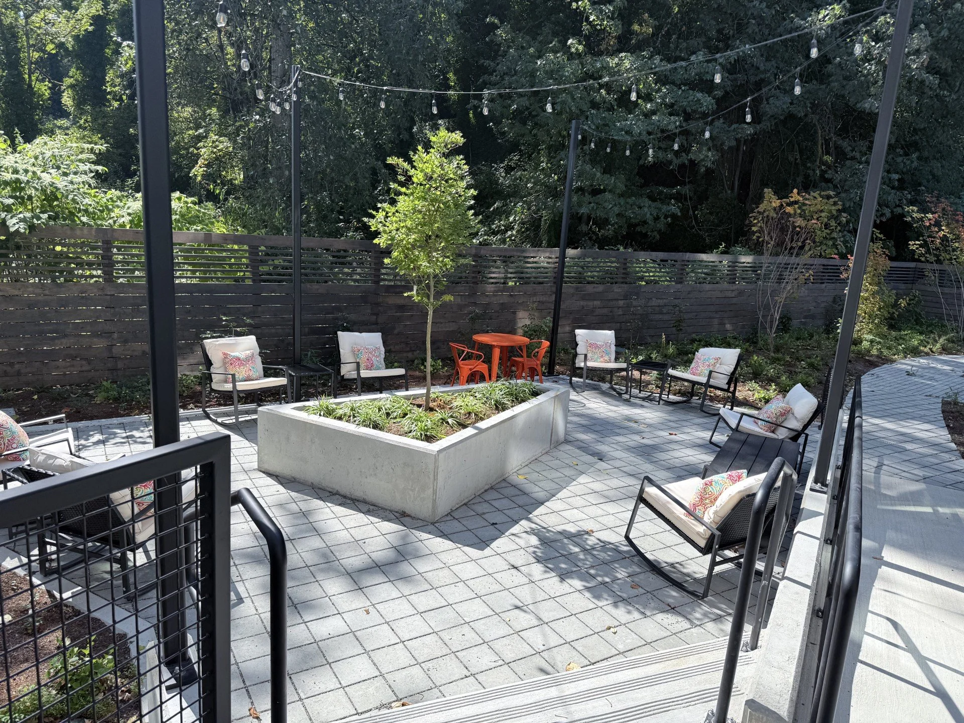 Outdoor patio space featuring lounge seating and a fireplace, offering a comfortable setting for relaxation and social gatherings.