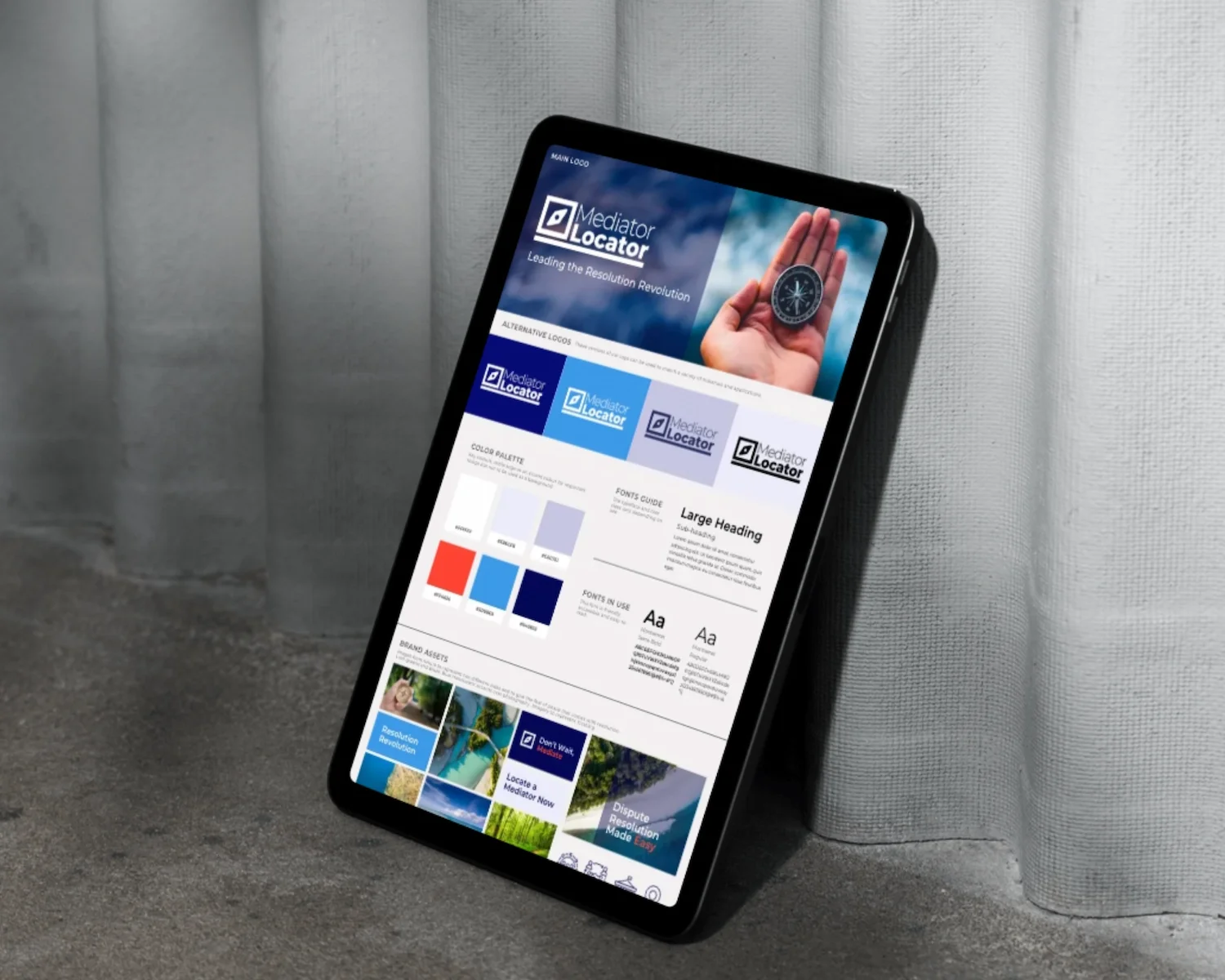 An electronic tablet displaying a branding and style guide for Mediator Locator, placed against a gray concrete surface and a white curtain.