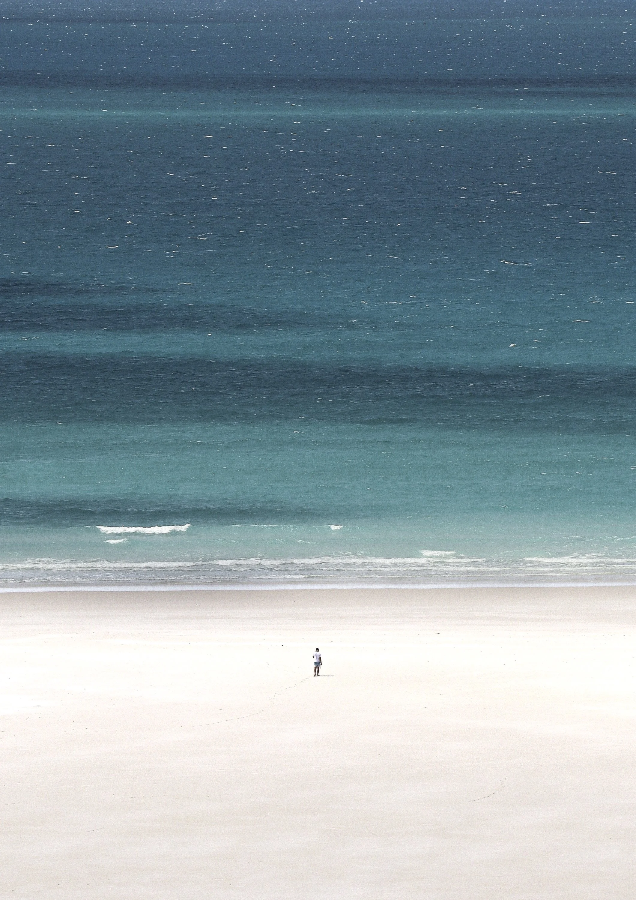 A man on a vast beach with ocean