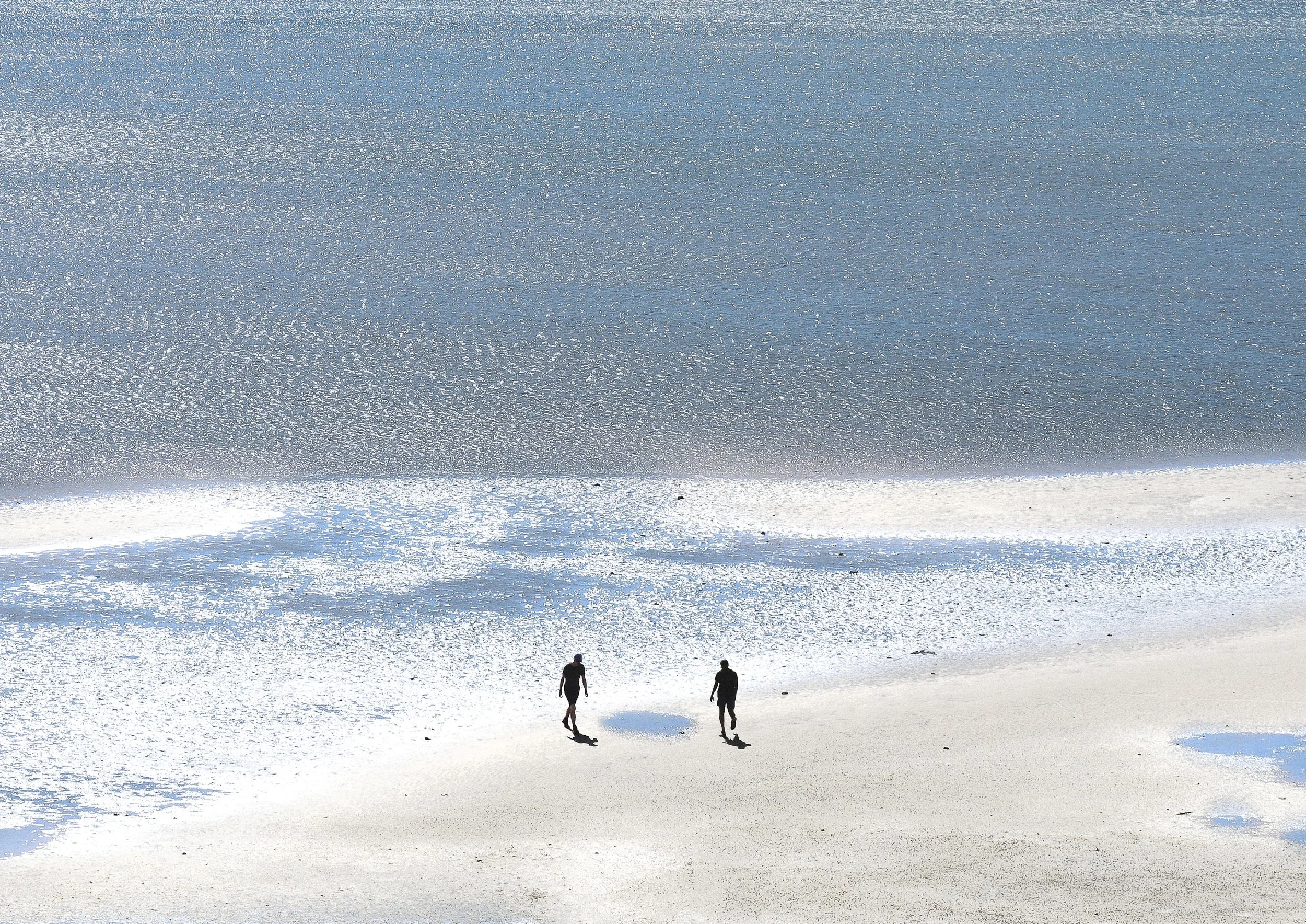 2 people on a vast beach with ocean