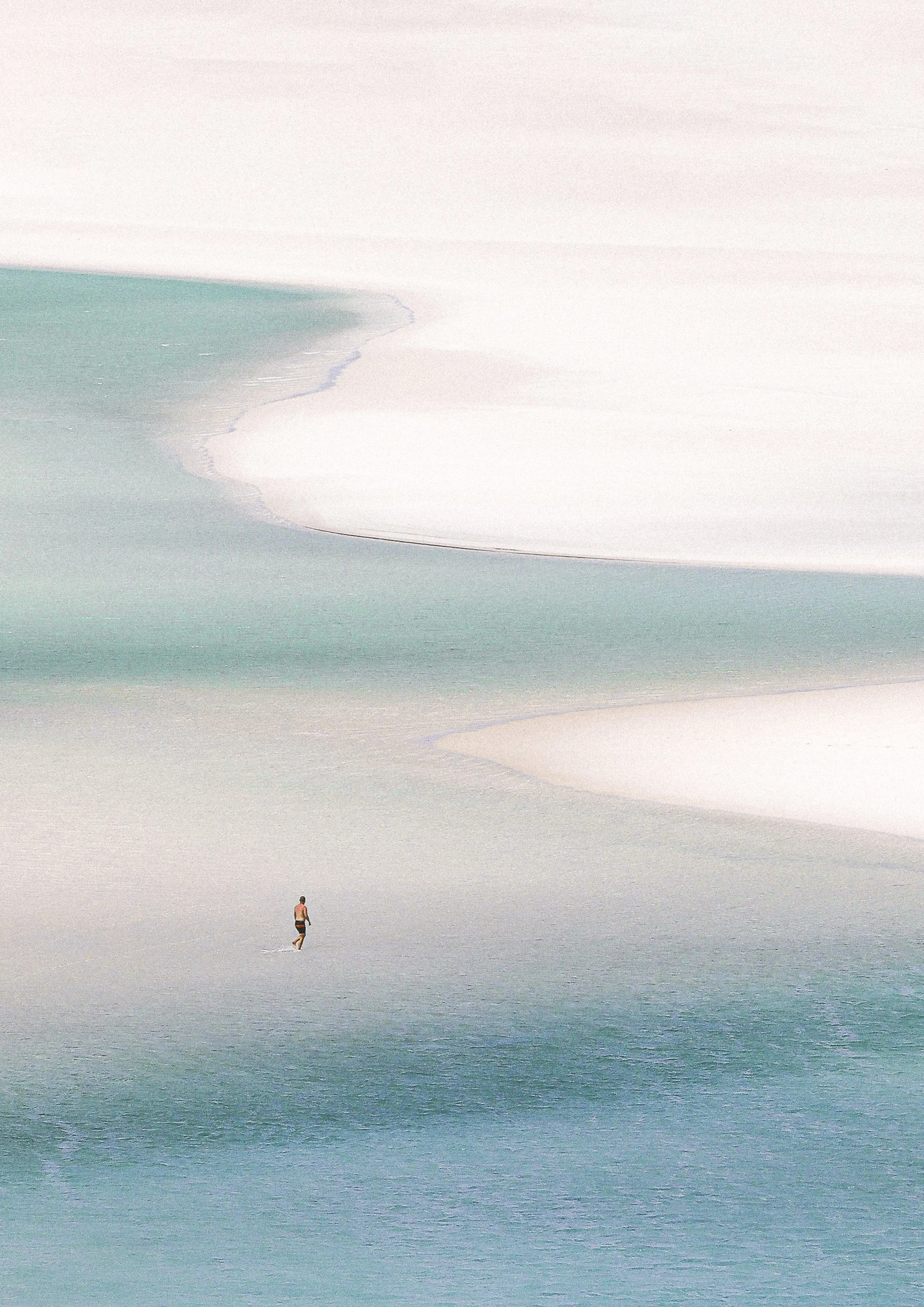 A man on a vast beach with ocean