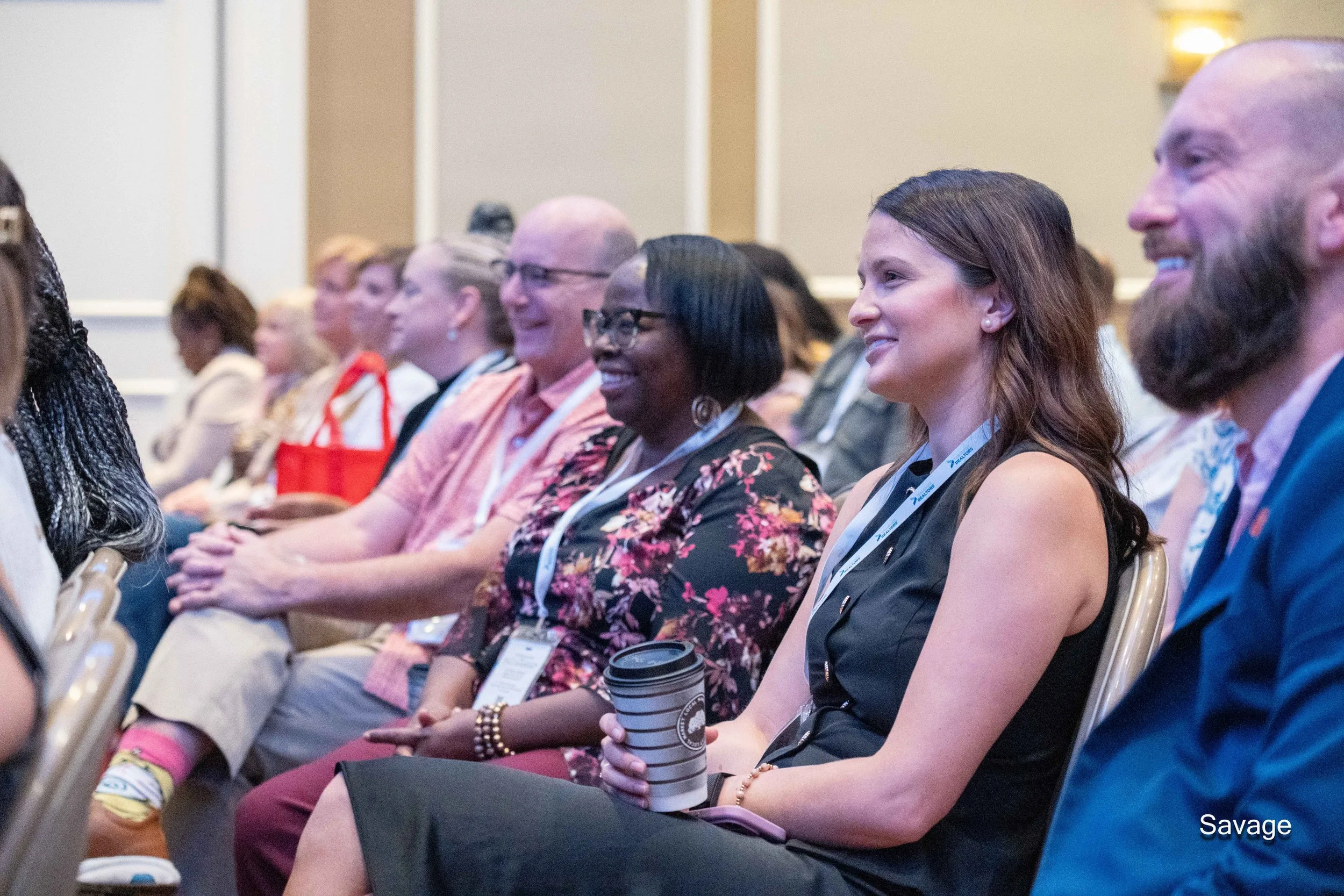 Audience at a conference smiling and engaged.