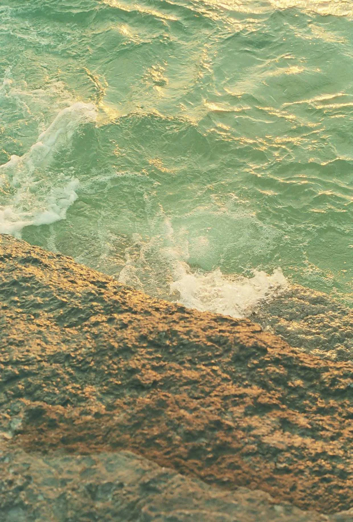 View of ocean waves crashing against rocky shore.
