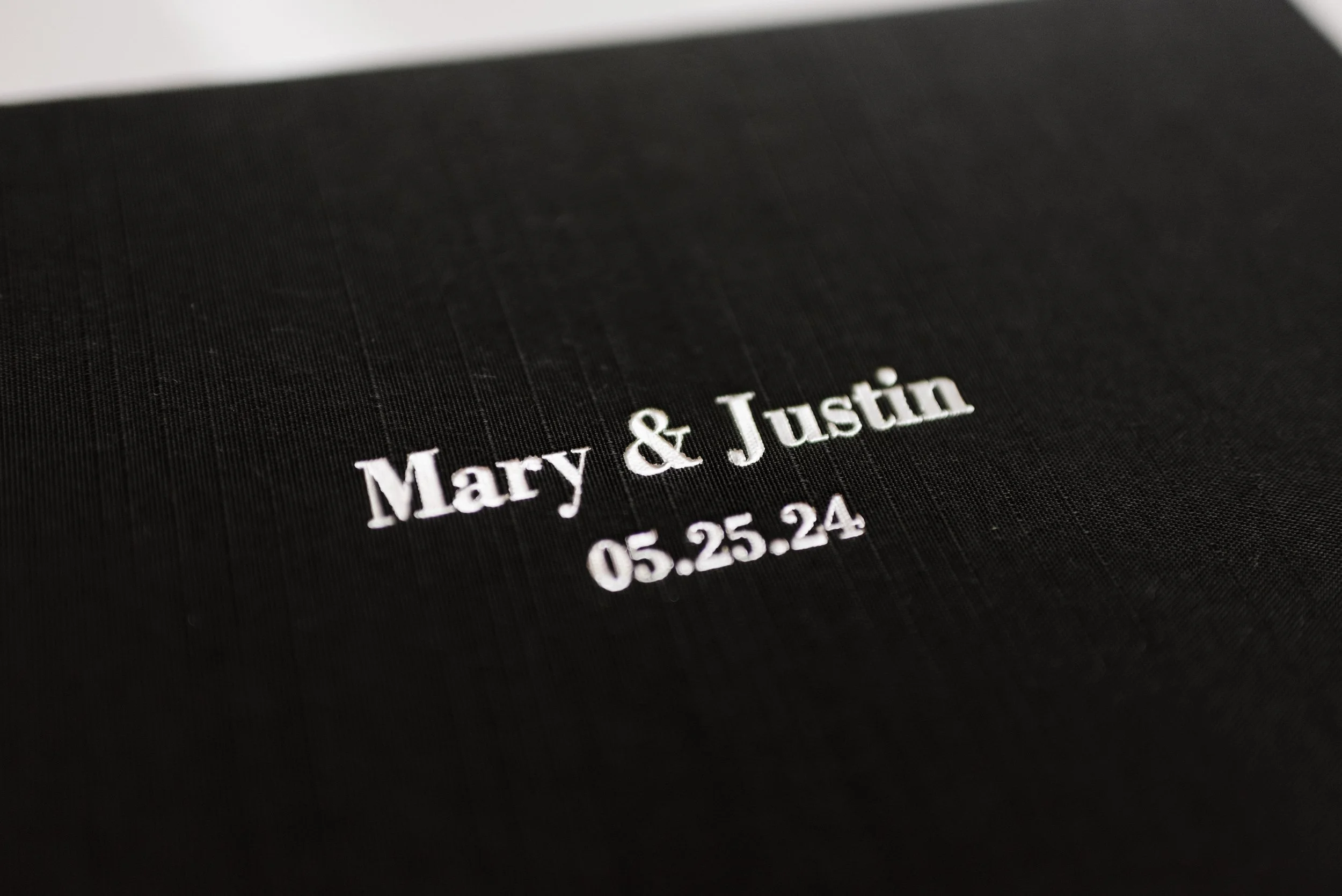 A close-up of a black linen-bound heirloom photography album, highlighting the artistic archiving of memories through custom book design.