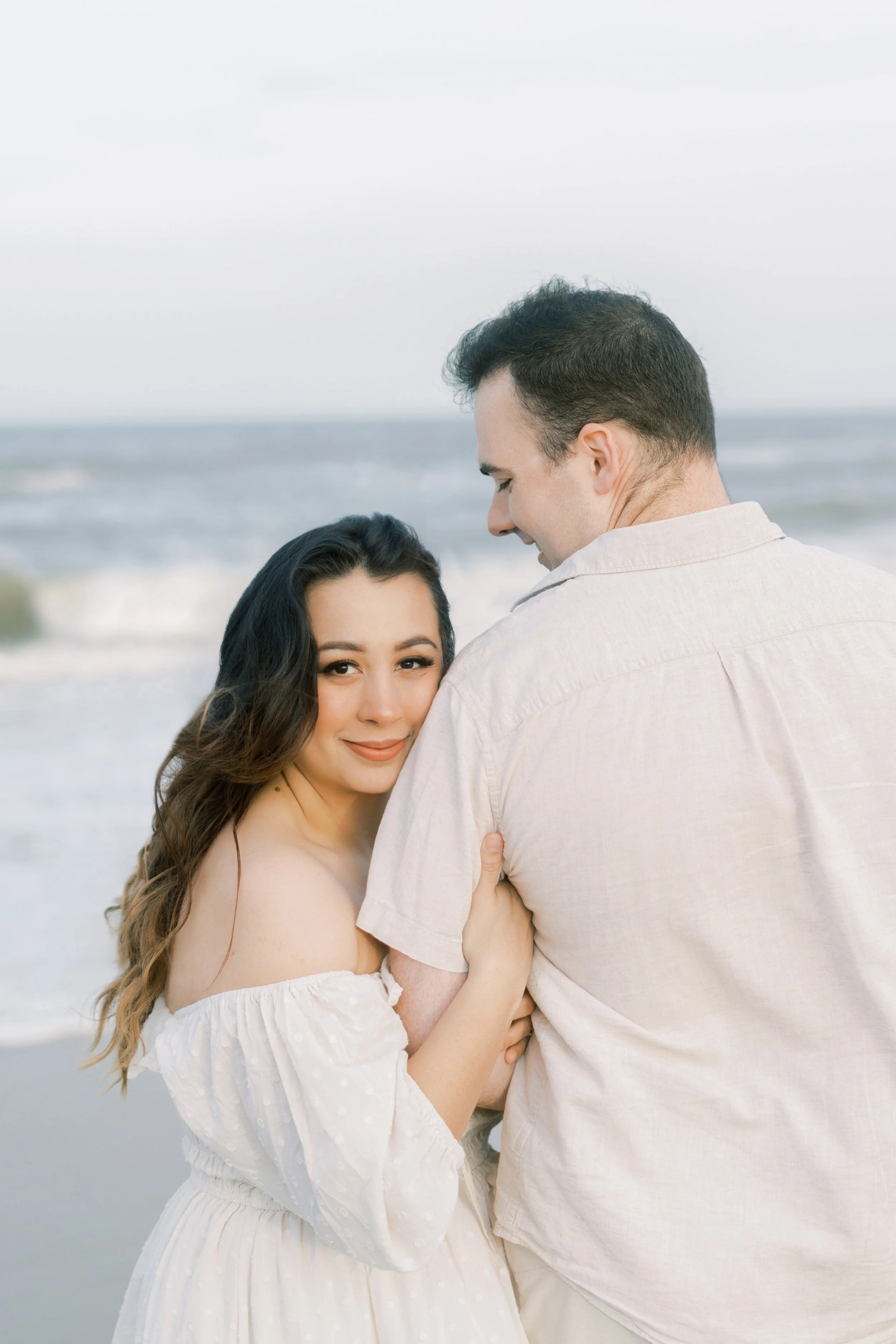 Engaged couple holding hands at the beach – Virginia Beach couples photography in a light and airy style