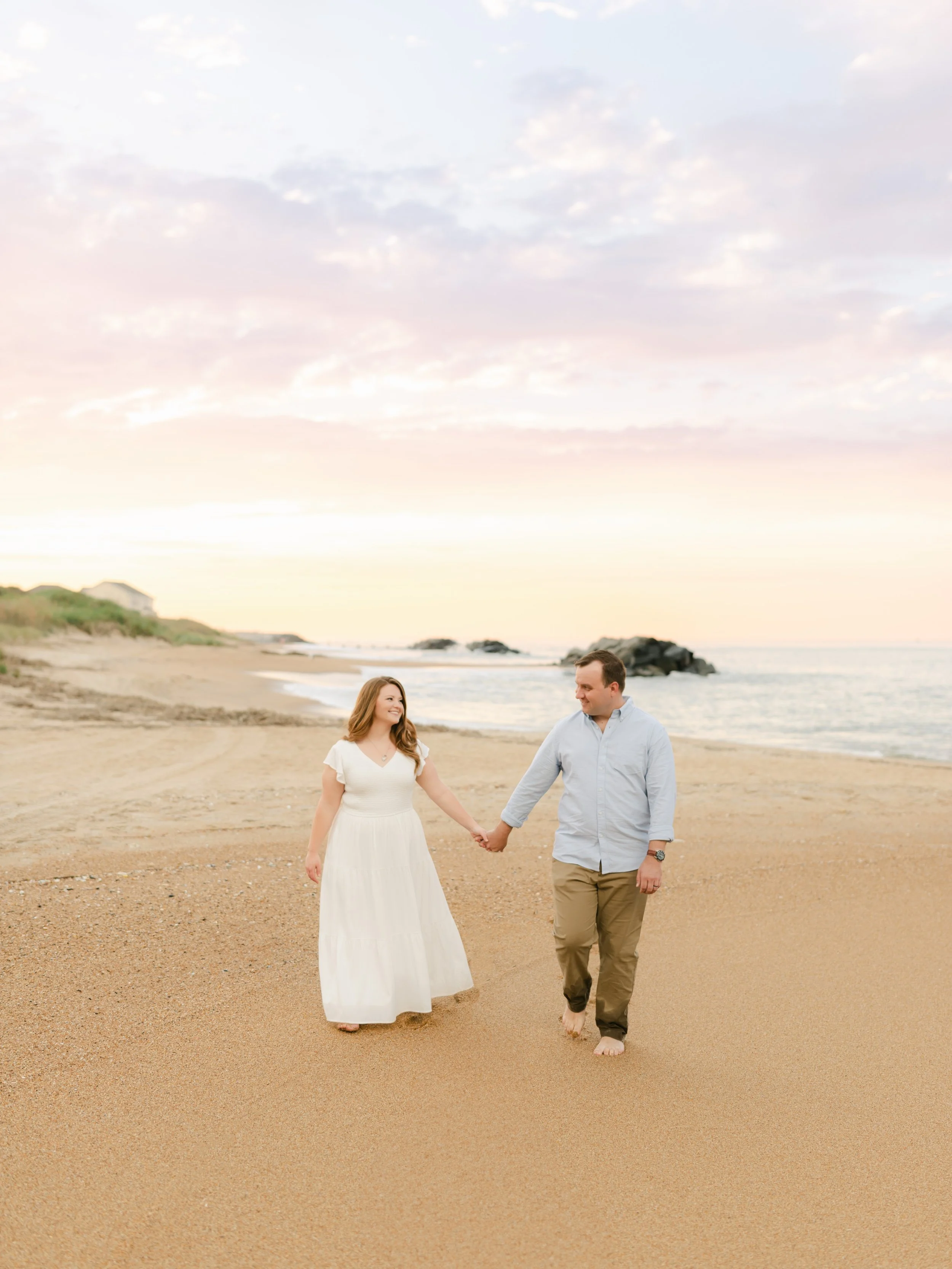 Light and airy couples photography on the beach in Virginia Beach at sunset — natural candid pose during a family session