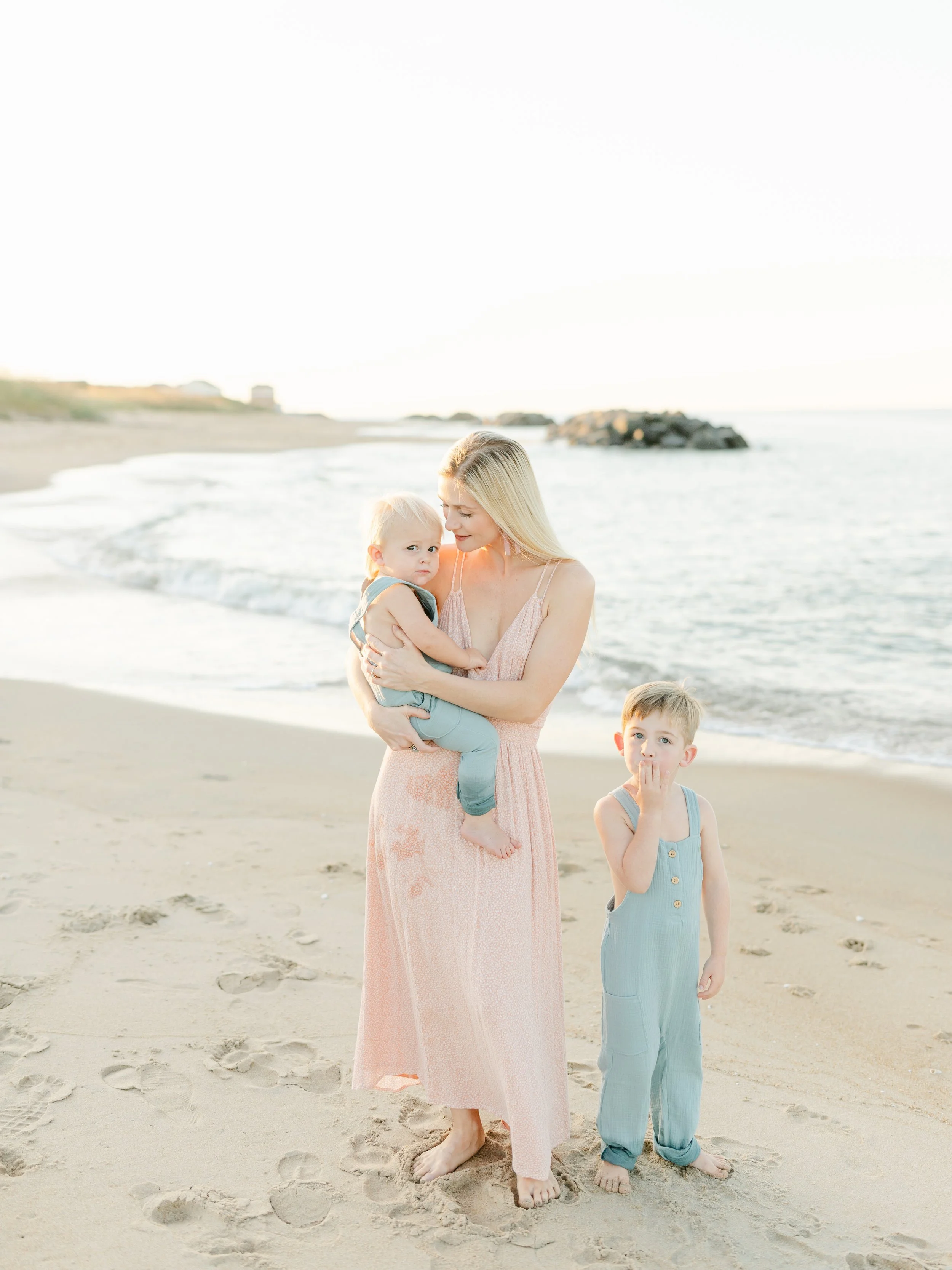 Mother with two children during a family beach session in Virginia Beach, capturing warm and natural moments.