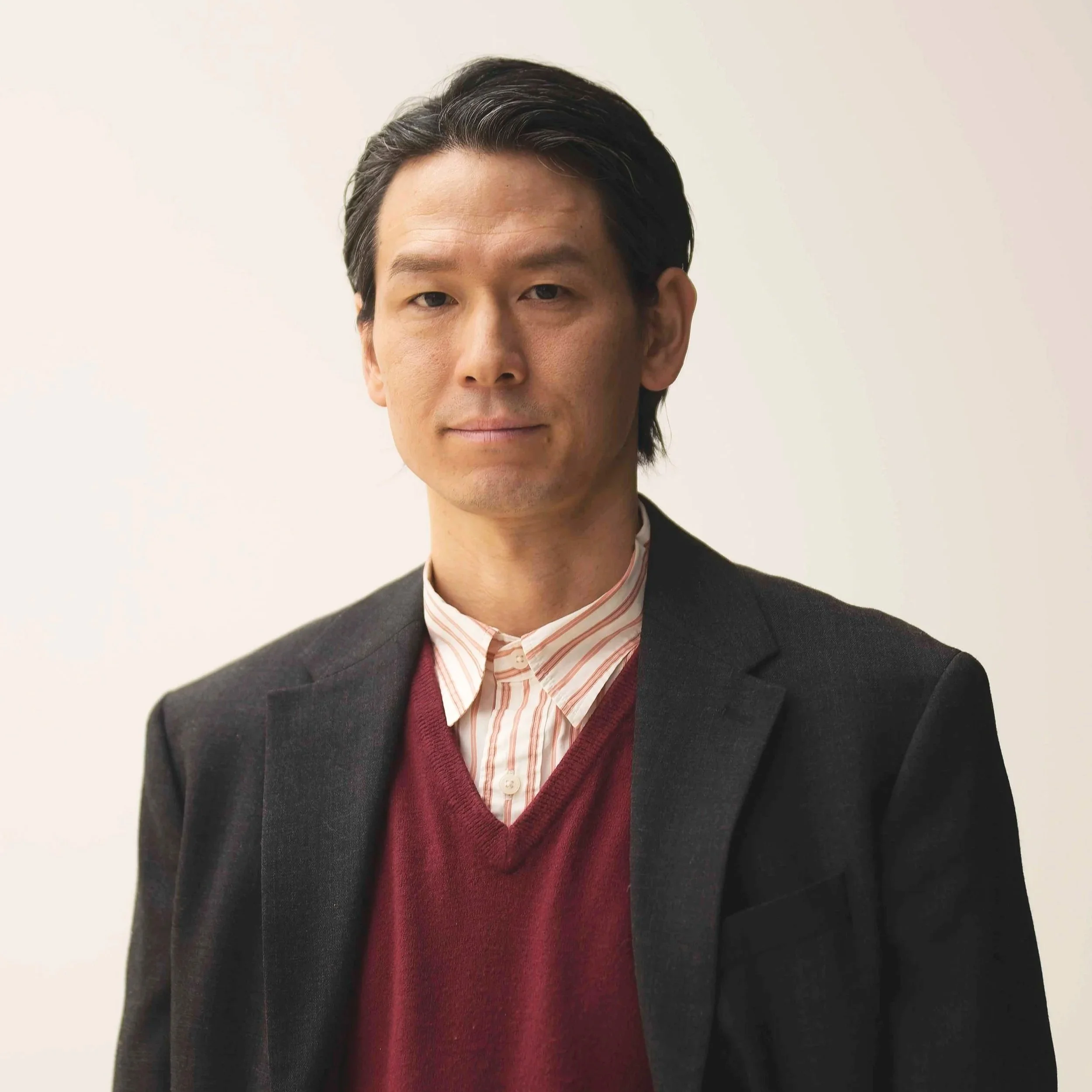 Man in brown leather jacket and checkered shirt