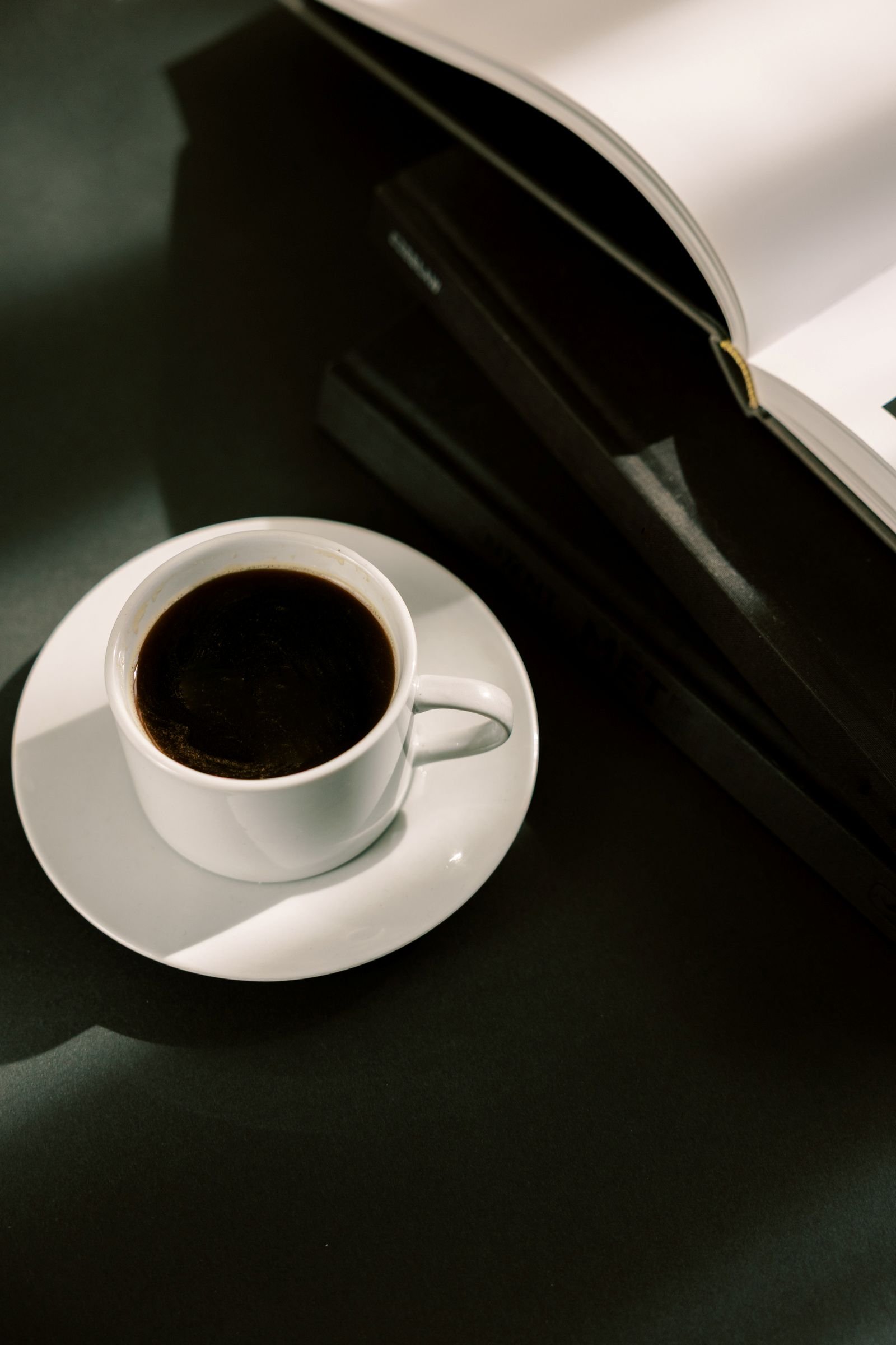 coffee cup on desk with open book