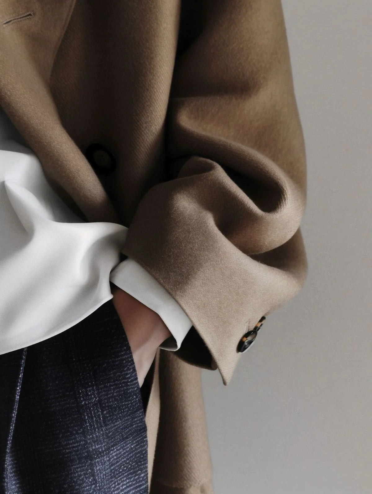 womans-hand-in-pocket-smart-brown-jacket-white-shirt-dark-trousers