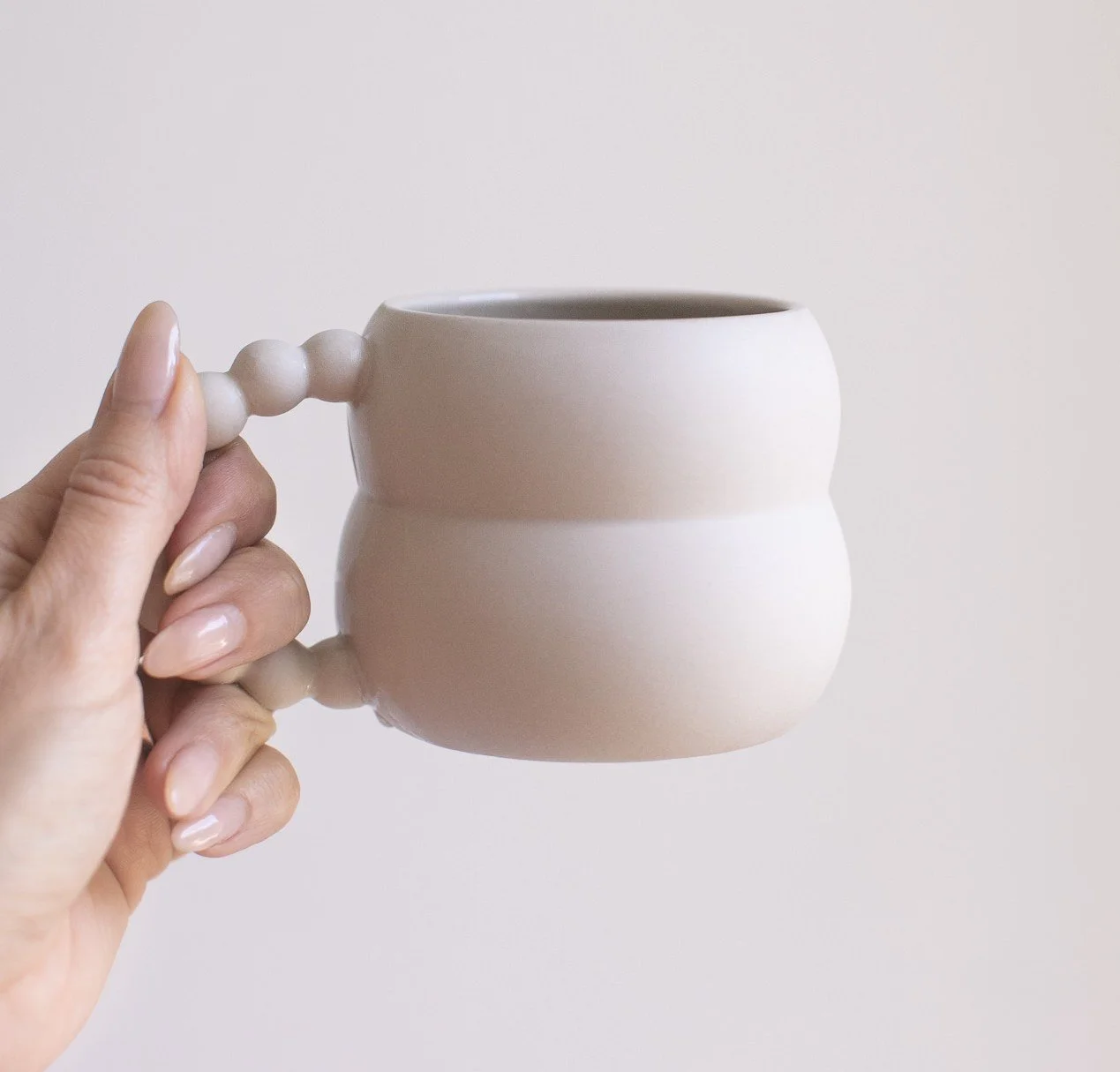 womans-hand-holding-coffee-cup