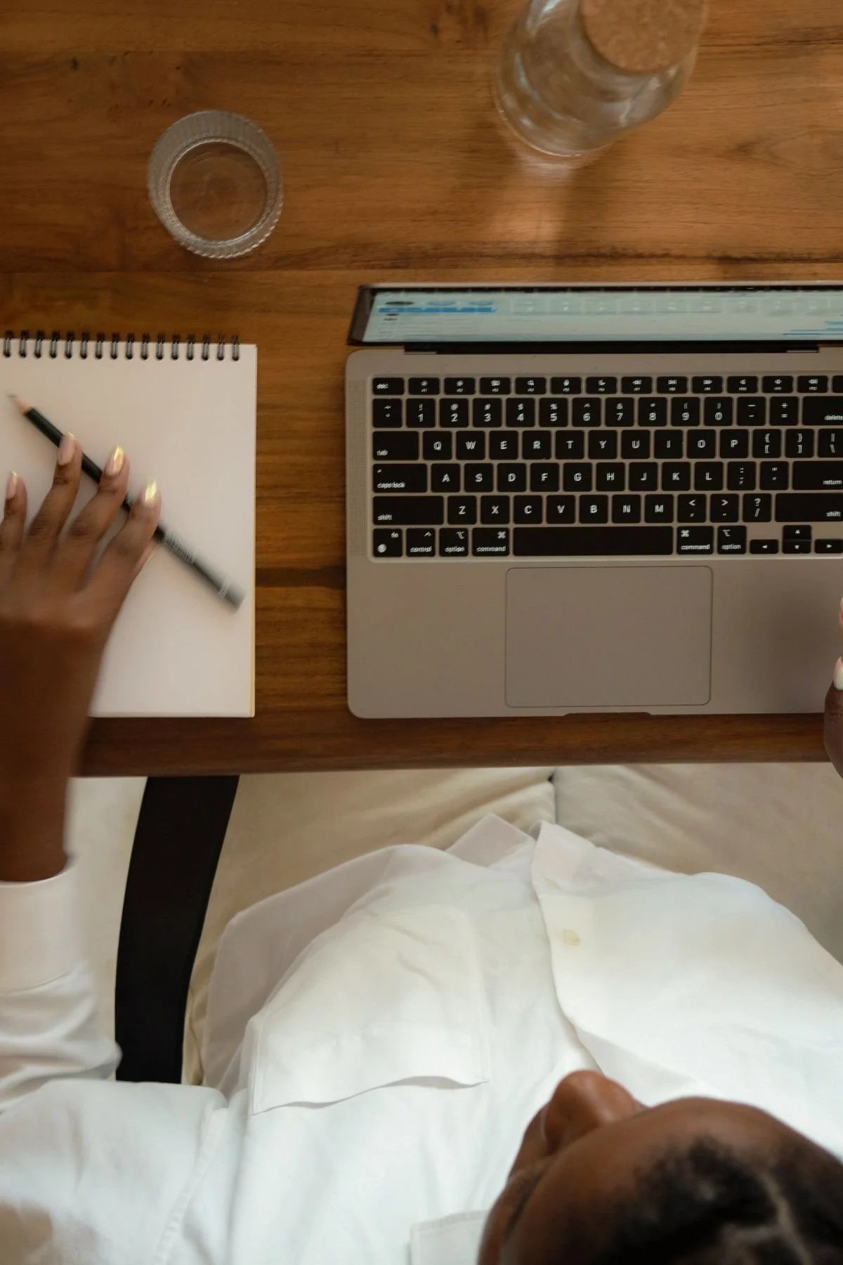 Overhead shot shows a woman working on a laptop, suggesting a relaxed and focused work environment.