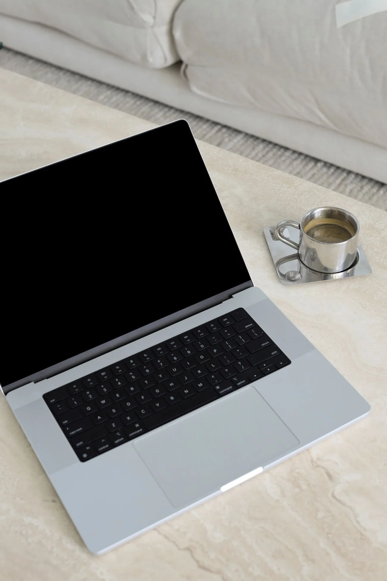laptop-on-coffee-table-next-to-silver-coffee-cup