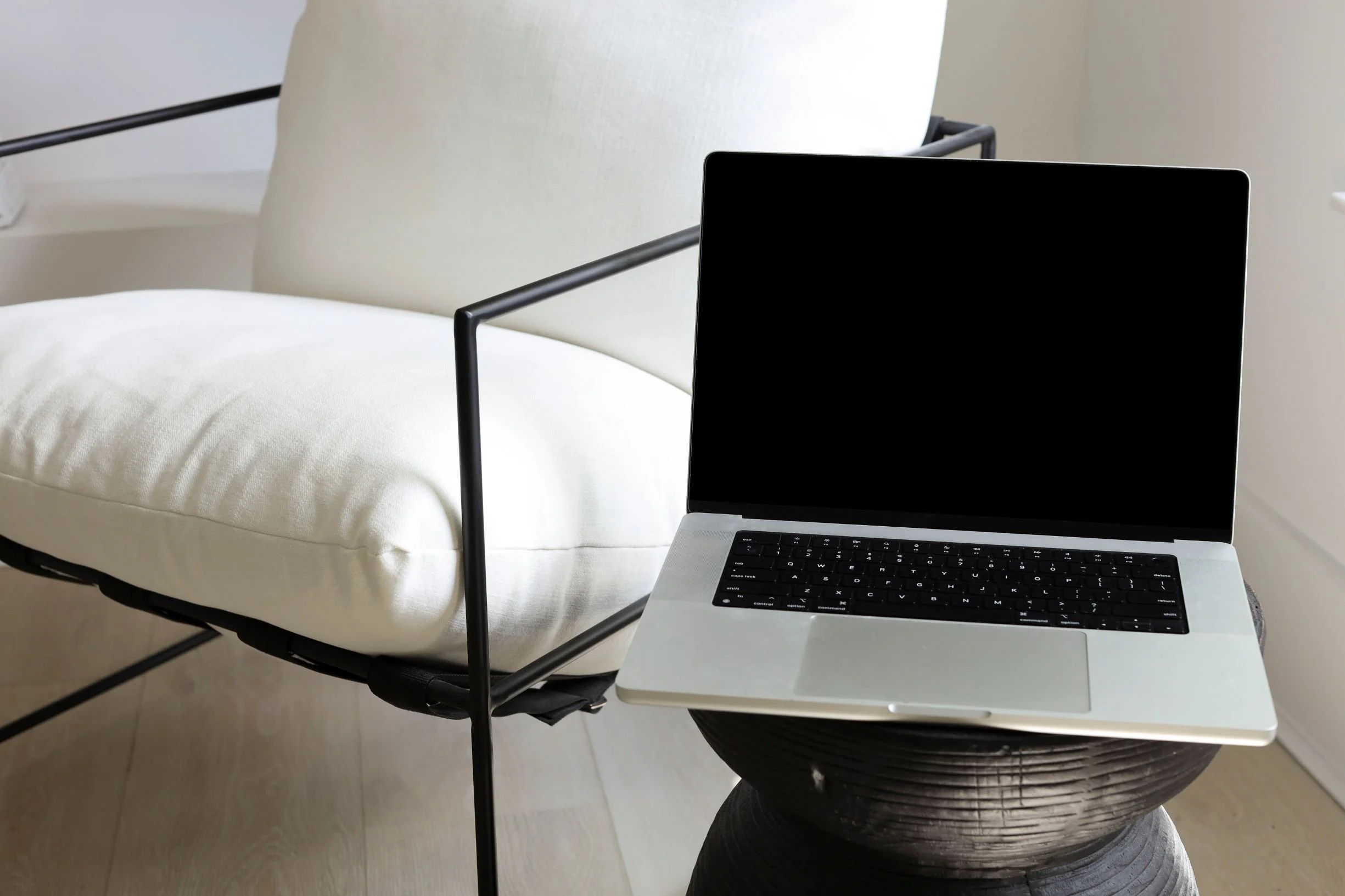 white-chair-with-open-laptop-on-side-table