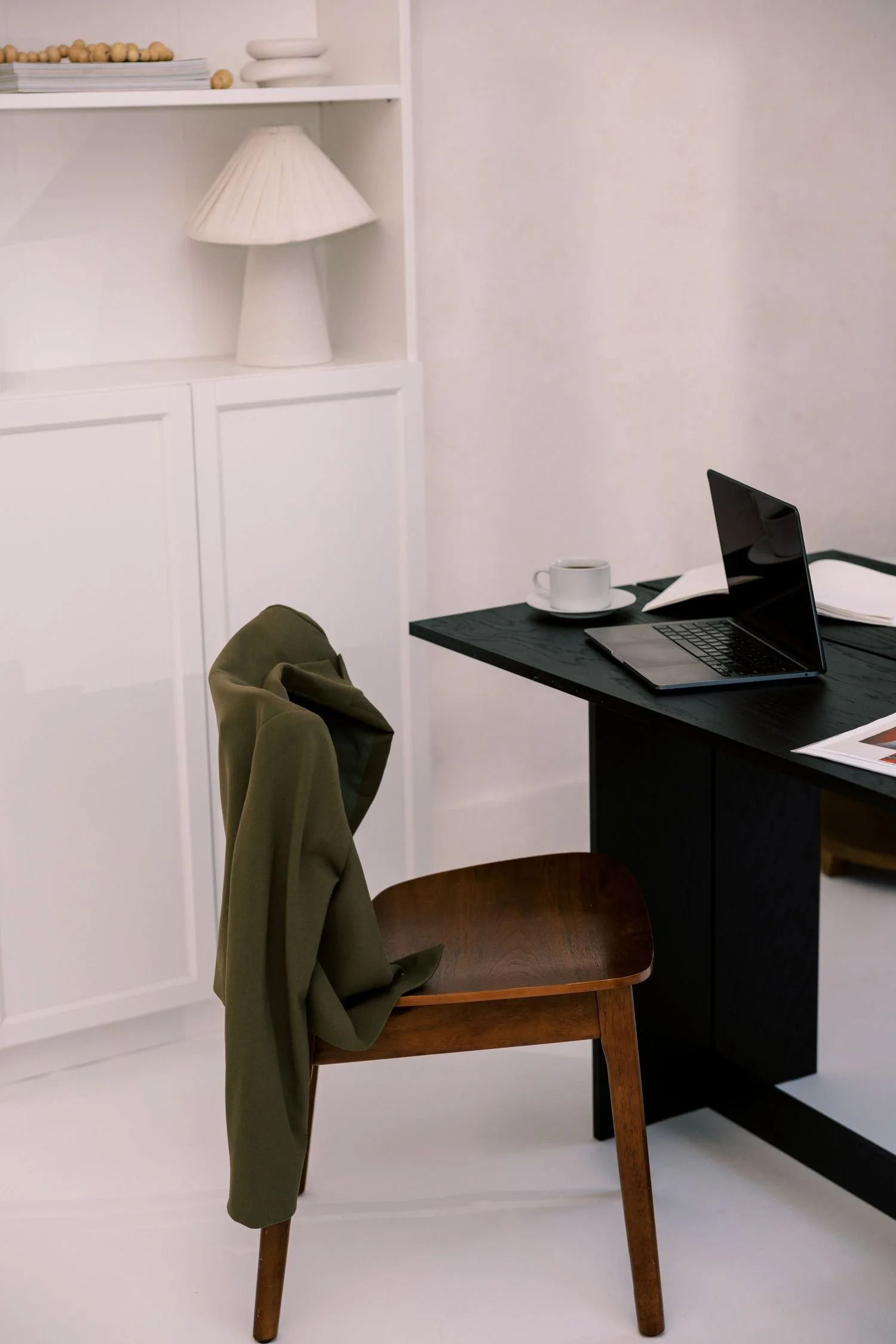 laptop-coffee-cup-and-notebooks- on black-table-in-white-home-office