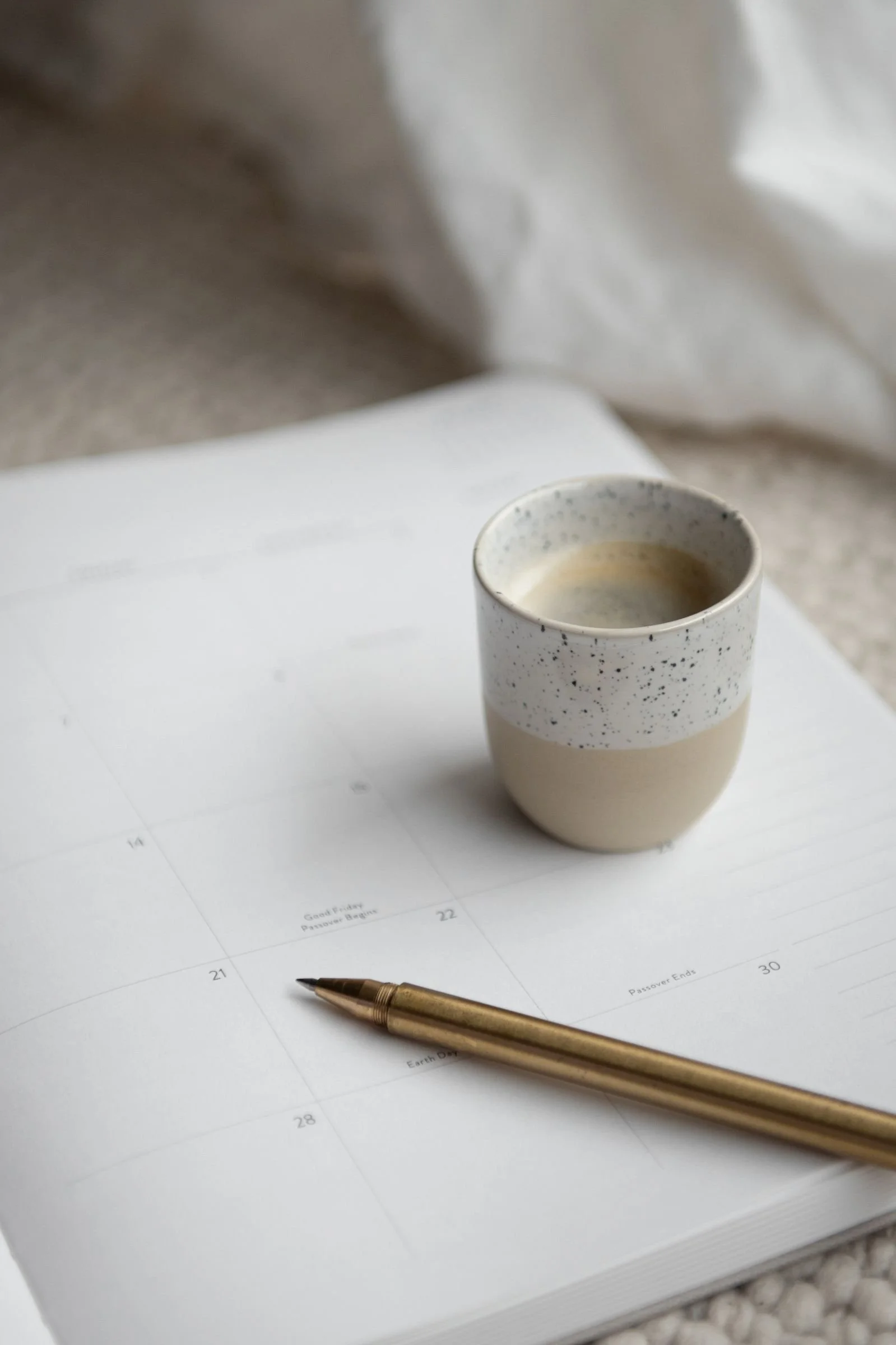 earthy-coffee-cup-on-desk-calendar-golden-pen