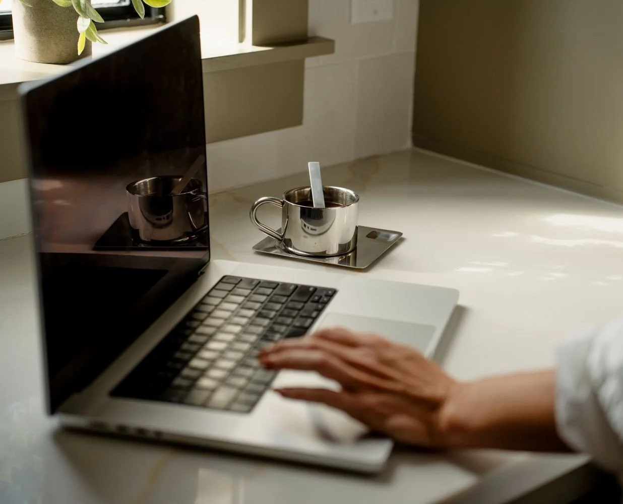 laptop-near-window-woman-typing-silver-coffee-cup