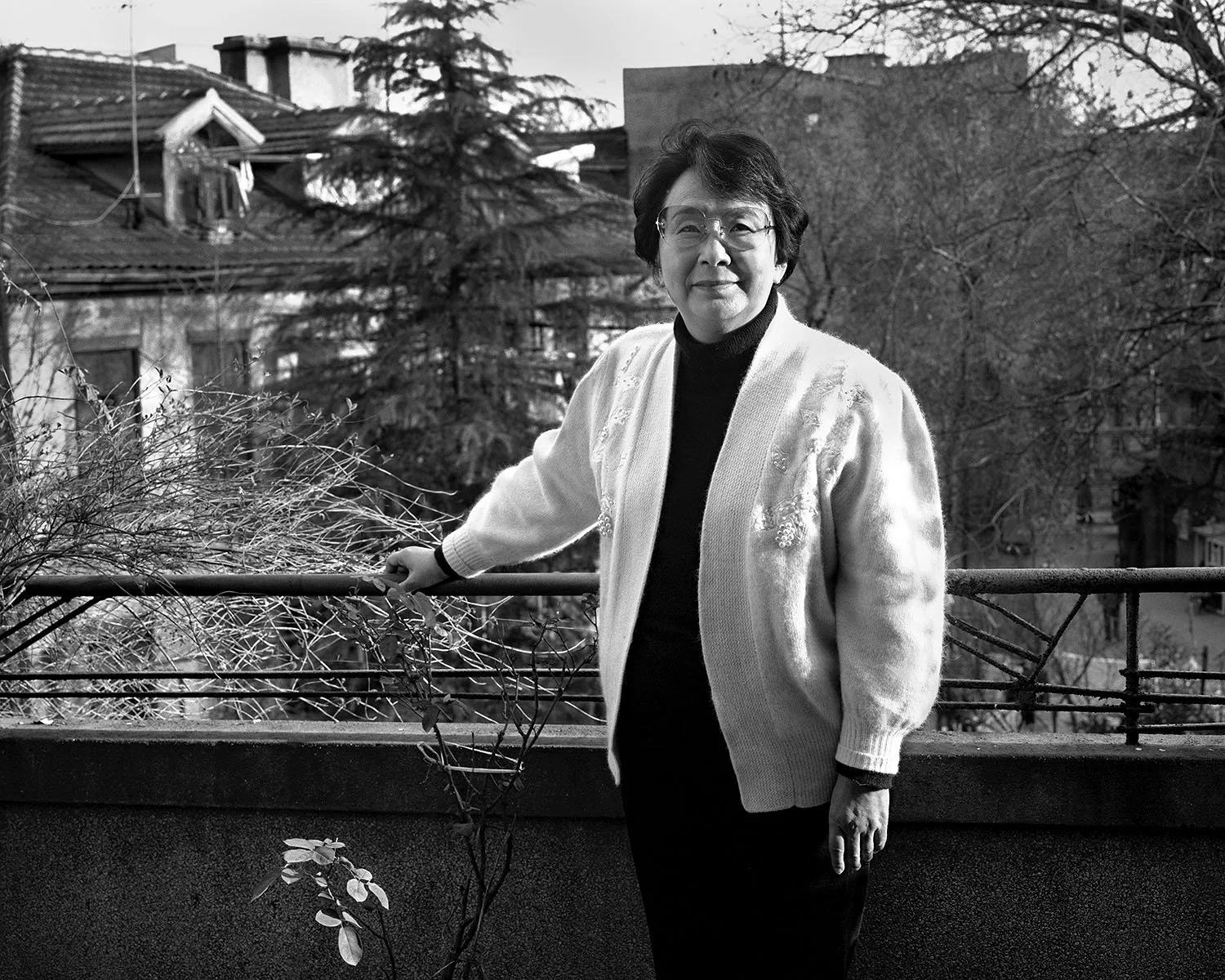 Monochrome portrait of feminist advocate Li Ziyun standing on her balcony in Shanghai, 1995.