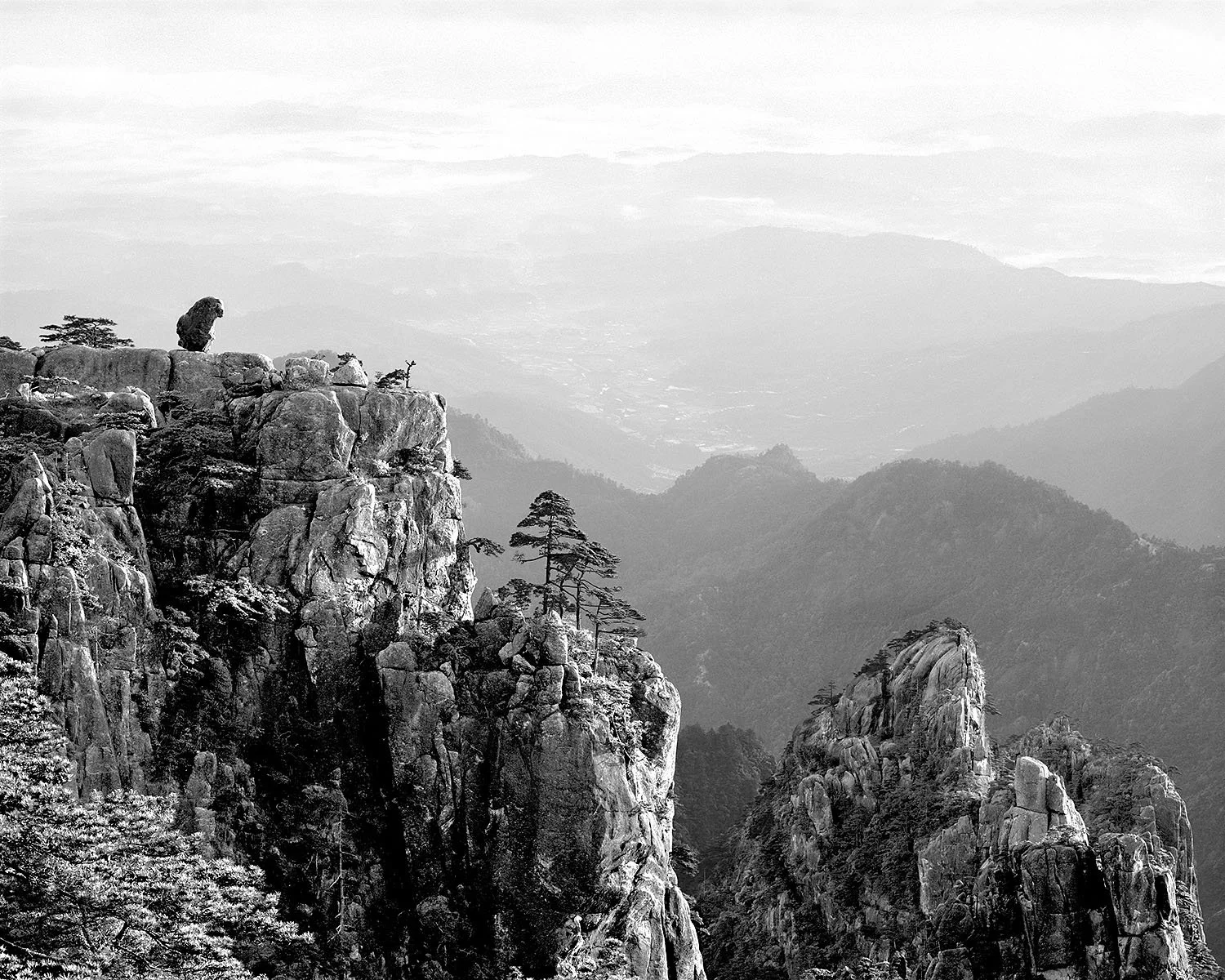 Black and white photograph of Stone Monkey Peak on Yellow Mountain, Anhui Province, China, showing granite cliffs and distant valleys, 1986.