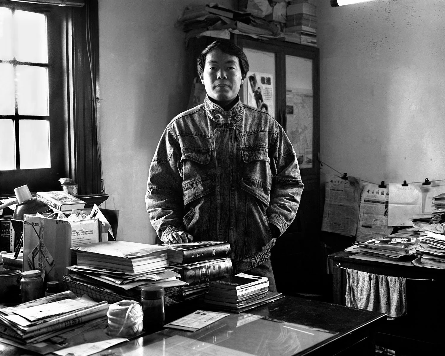 Editor and publisher Li Zhang standing behind his desk in Shanghai, 1988.