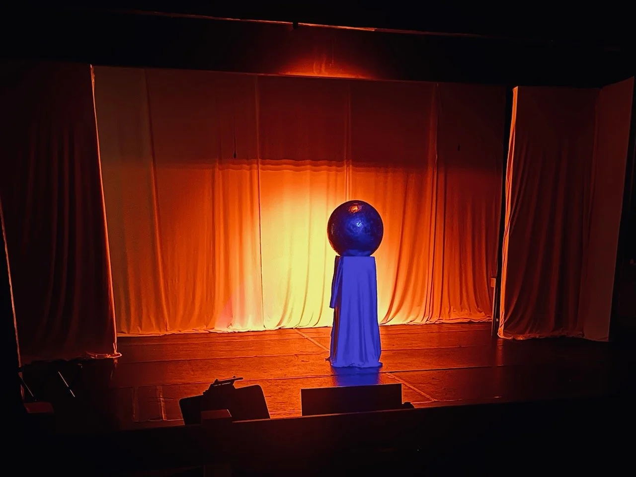 Orb on pedestal on stage, backlit. Chromalume from Sunday in the Park with George