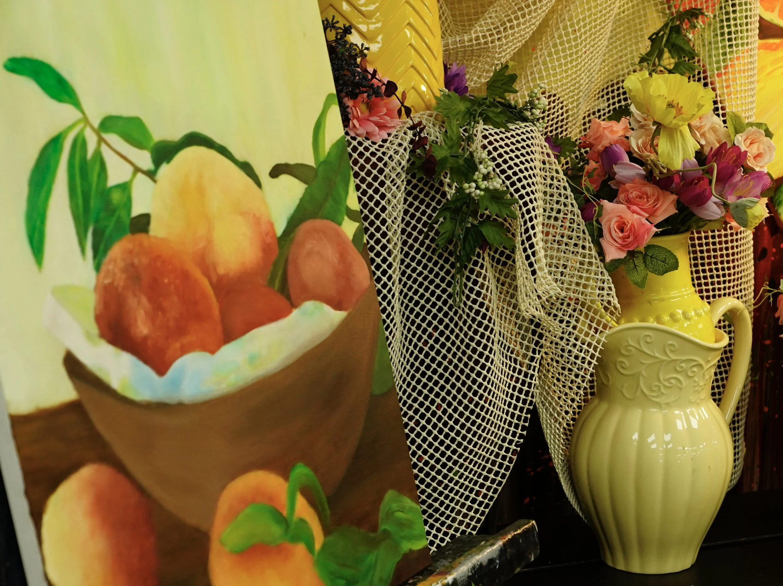 Still life arrangement with painting, flowers, and pitcher