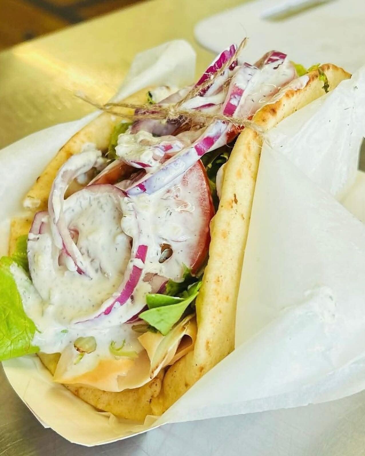 Pita wrap with turkey, lettuce, tomatoes, red onion, and creamy dressing.