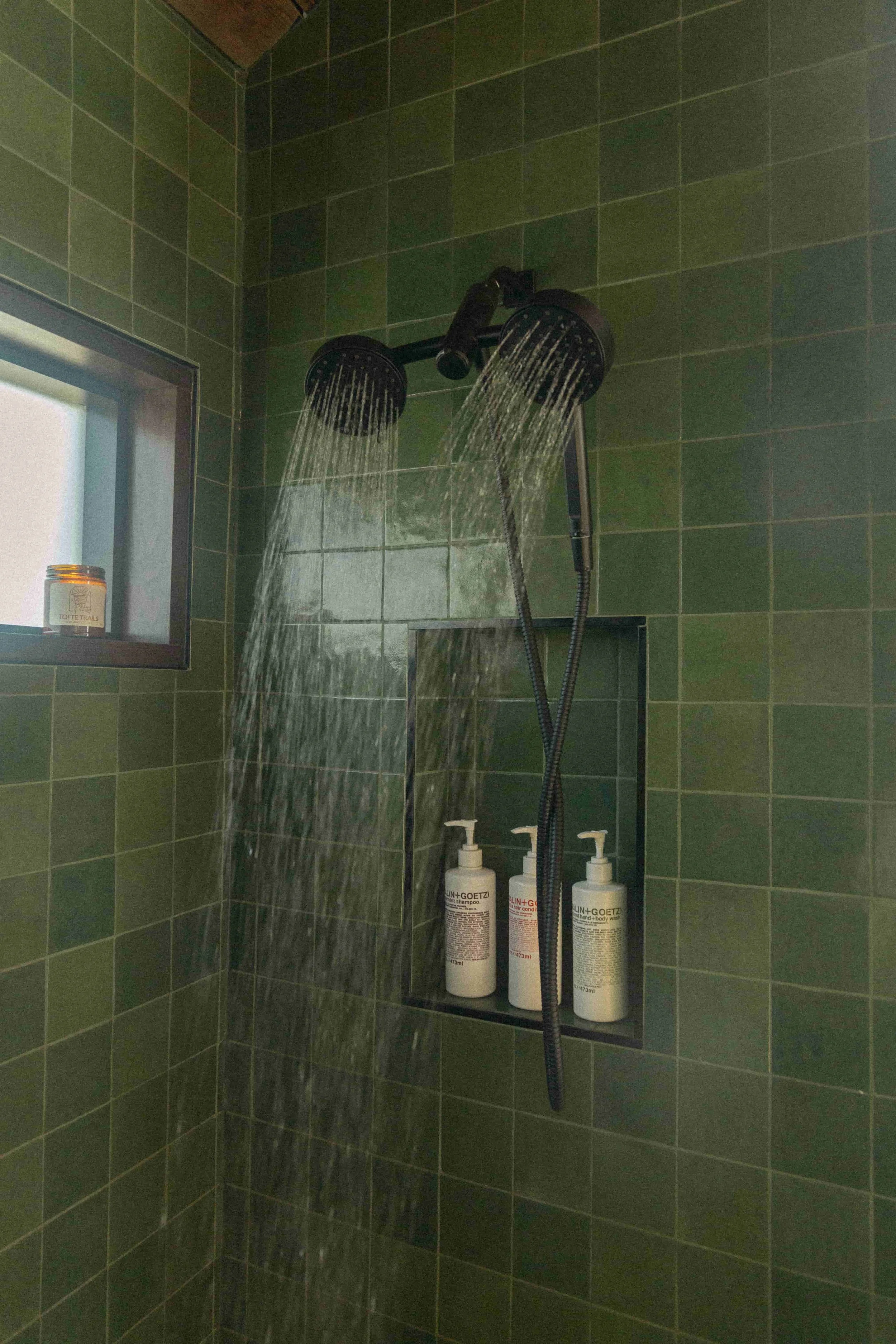 Luxury cabin bathroom with spa style walk-in shower and green tile on Minnesota’s North Shore