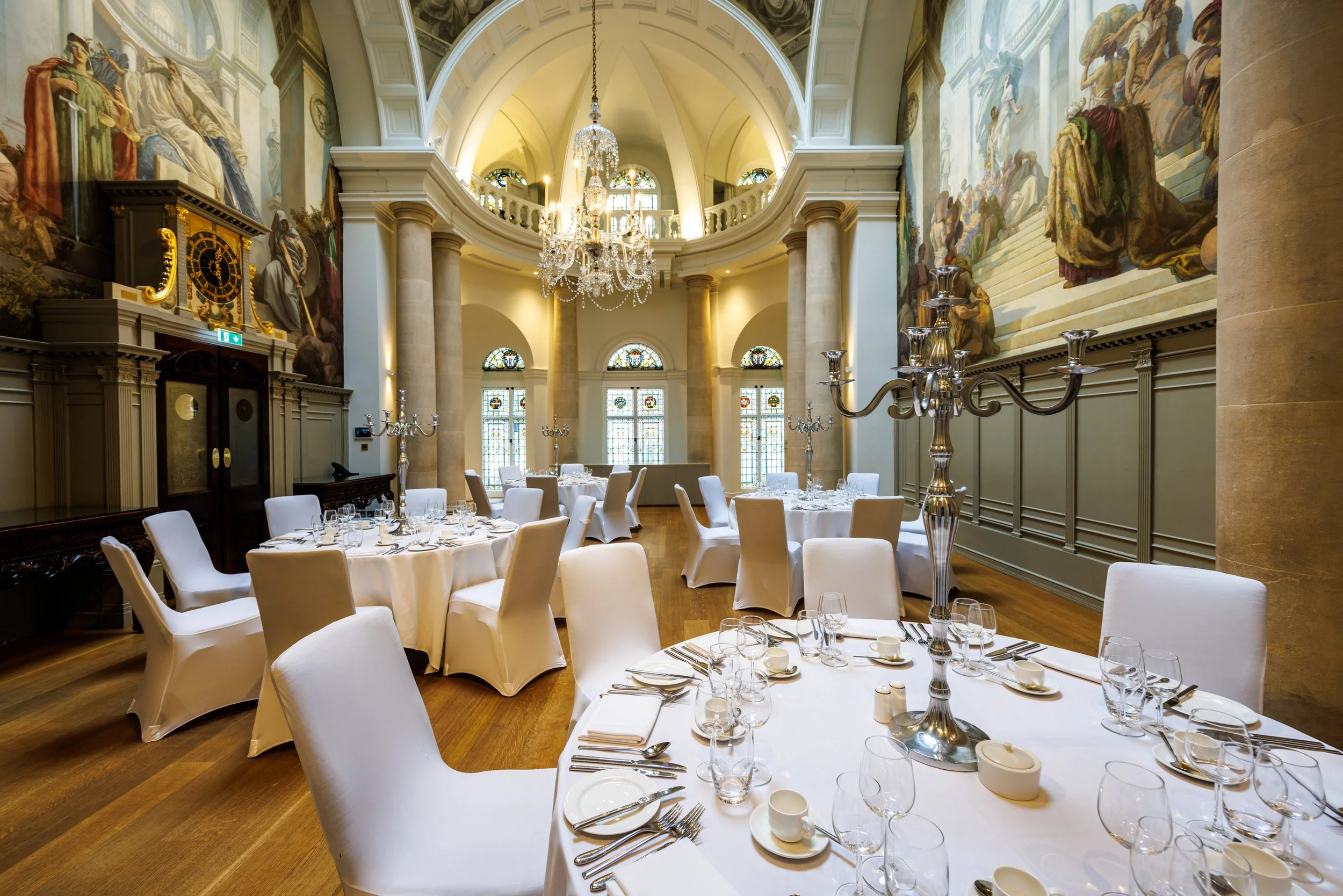 Elegant dining hall with round tables and silverware prepared for a gala dinner