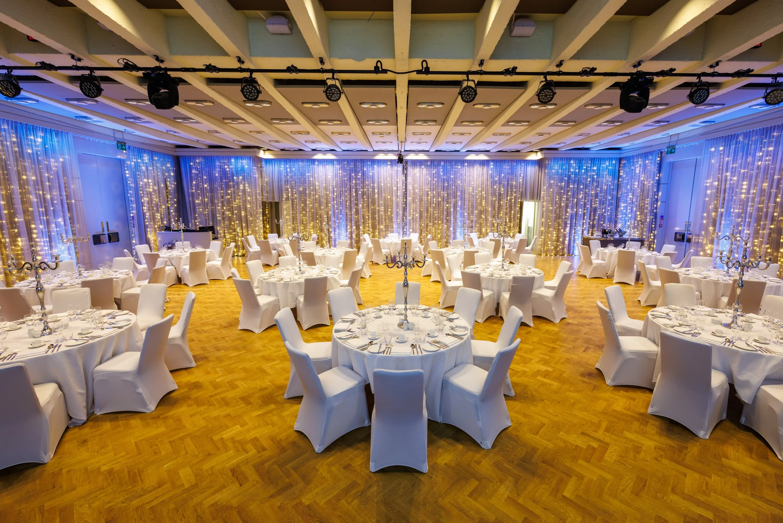 Elegant banquet hall setup with round tables and chandeliers