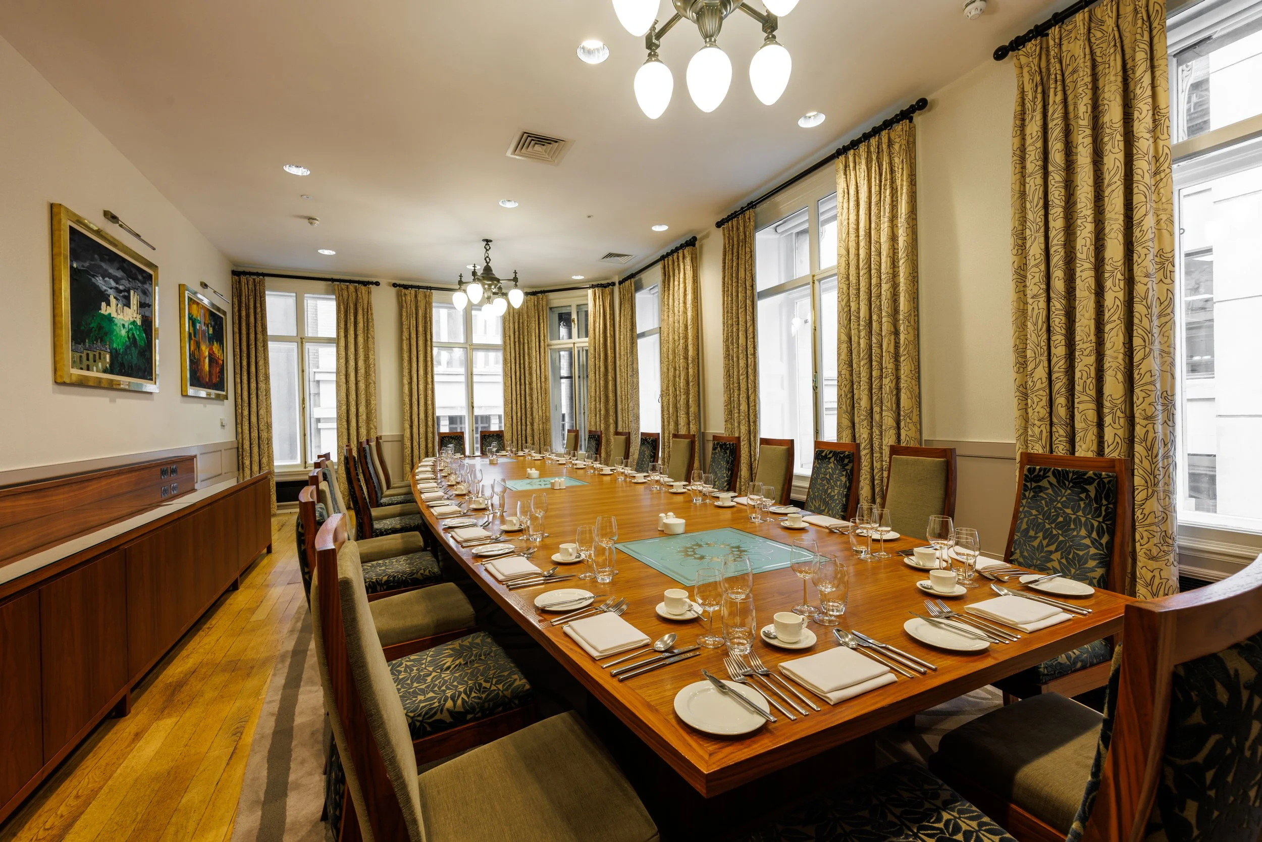 Meeting room setup with long wooden table for corporate events