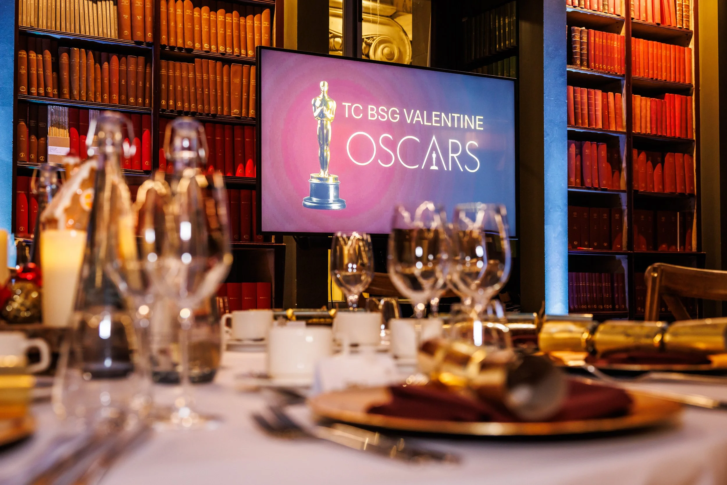 Corporate gala dinner table setting with branded awards screen