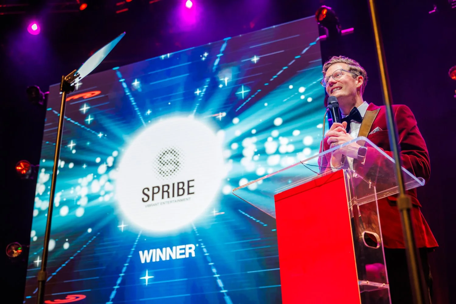 Awards host announcing category winner on stage