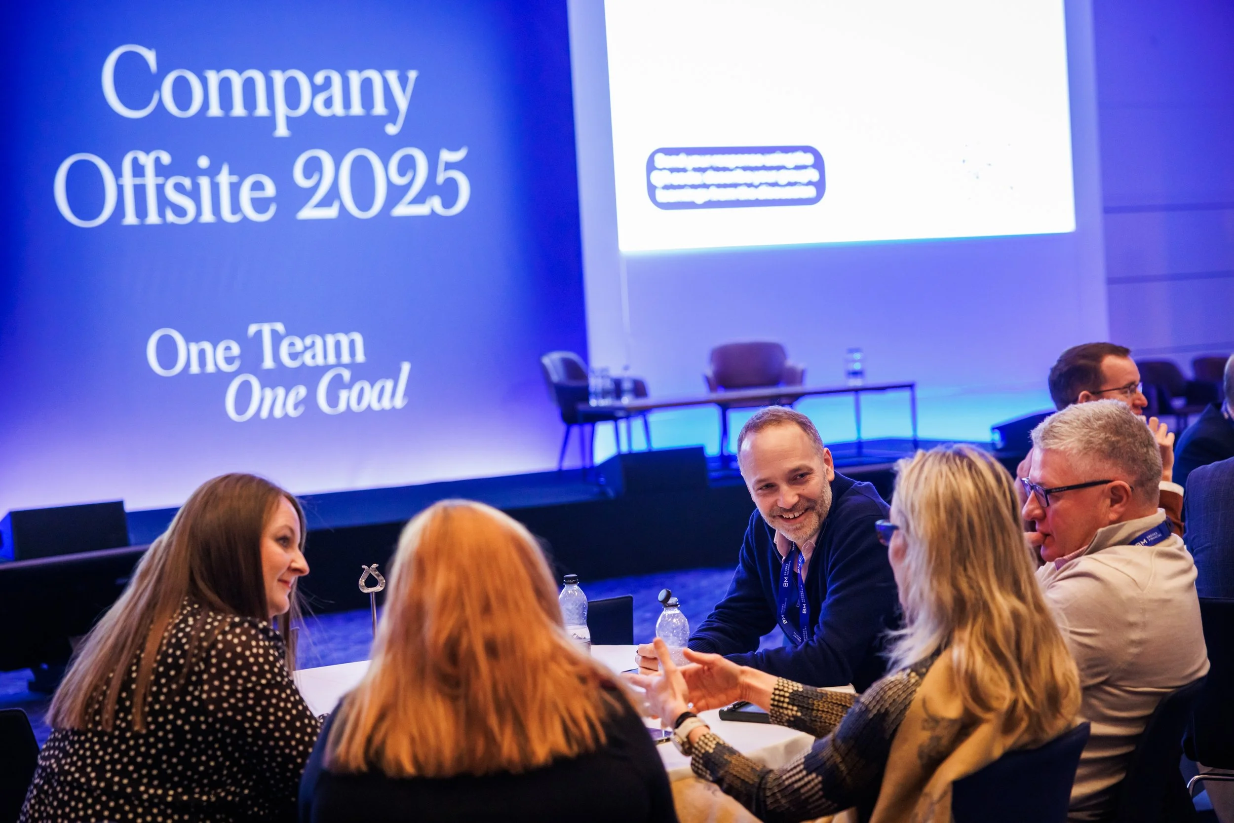 Corporate offsite delegates networking after a team presentation